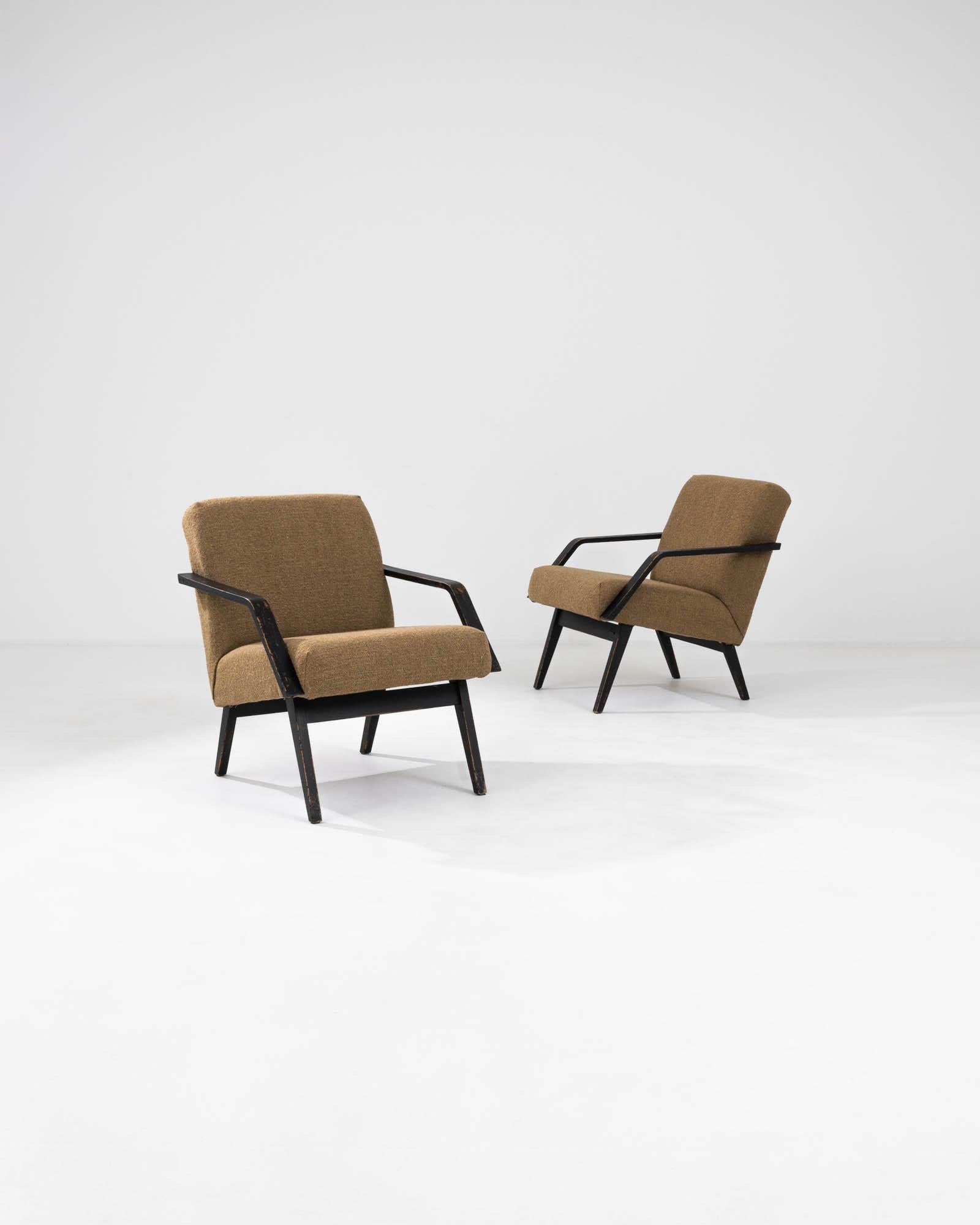 Voici une paire de fauteuils tapissés tchèques des années 1960 qui incarnent l'essence du design moderne du milieu du siècle avec un soupçon de flair européen. Revêtues d'un tissu texturé brun doré, ces chaises offrent une chaleur visuelle qui