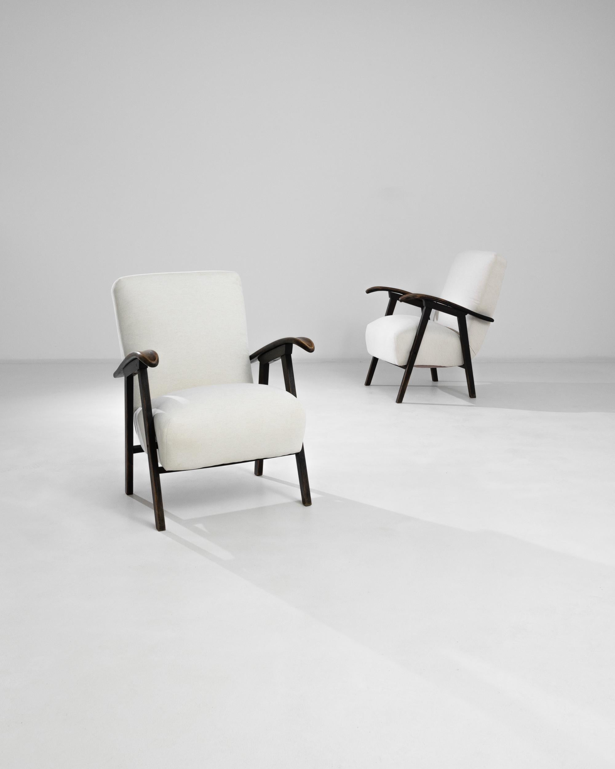 Eleganza nell'arredamento della tua casa con questa elegante coppia di poltrone imbottite ceche degli anni '60. Questi tesori vintage sono caratterizzati da eleganti telai in legno con braccioli delicatamente curvati, che offrono un perfetto mix di
