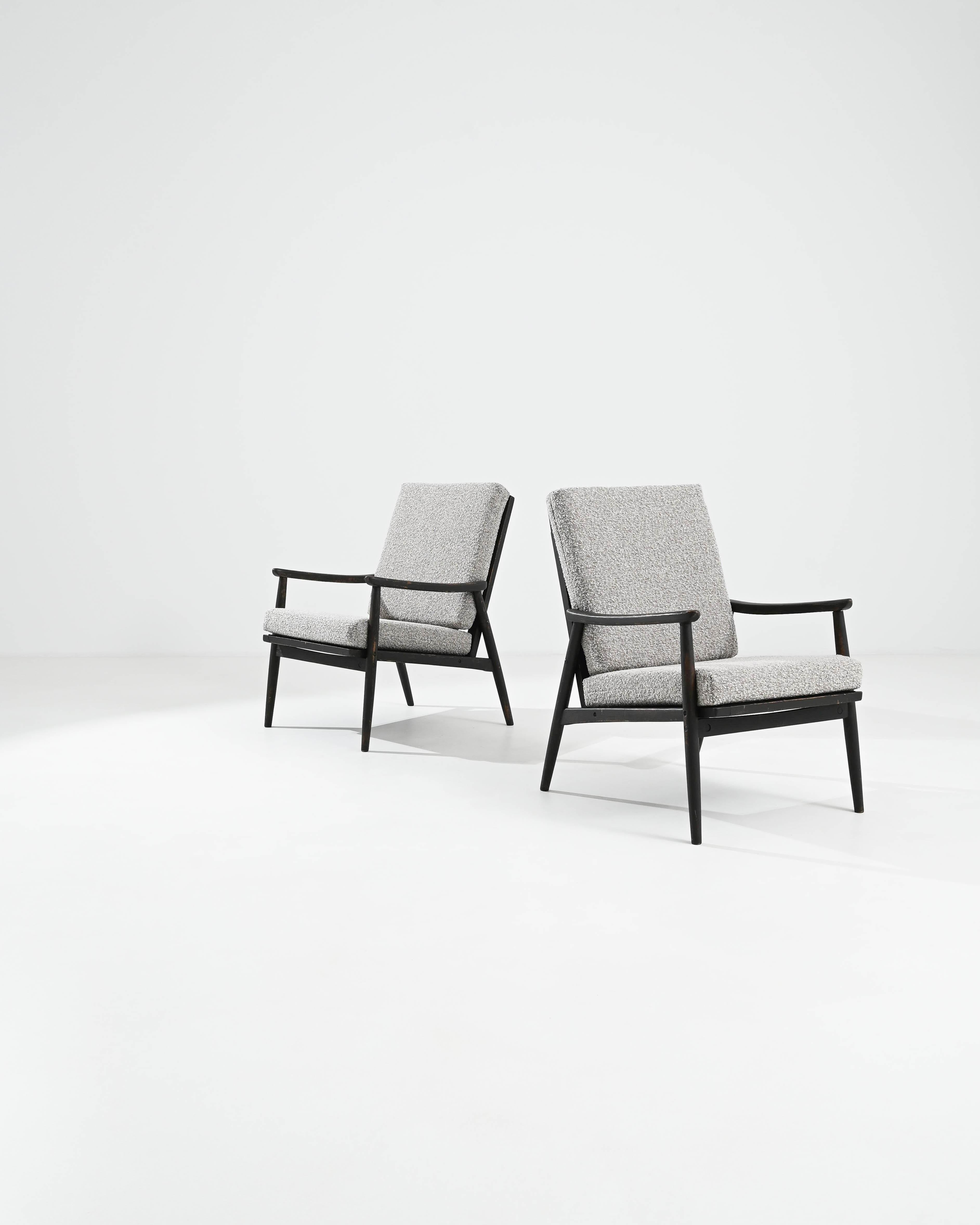 Élevez votre intérieur avec cette paire exquise de fauteuils tapissés tchèques des années 1960. Ces chaises sont dotées d'un élégant cadre en bois noir qui contraste magnifiquement avec le revêtement texturé gris, créant ainsi une esthétique moderne
