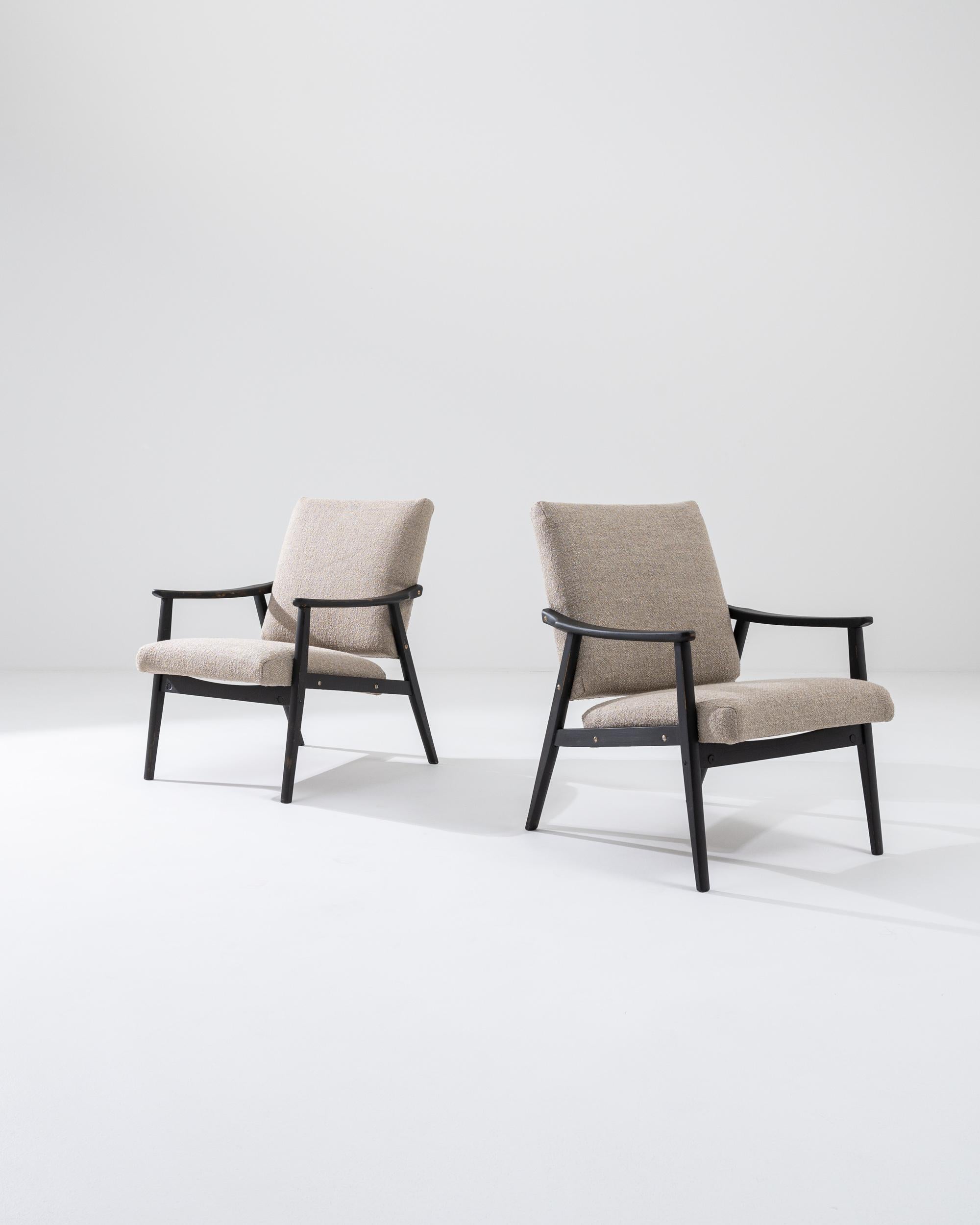 Ti presentiamo un'elegante coppia di poltrone imbottite ceche degli anni '60 che fondono perfettamente il design moderno di metà secolo con il comfort contemporaneo. Queste poltrone sono caratterizzate da un'elegante struttura in legno nero che crea