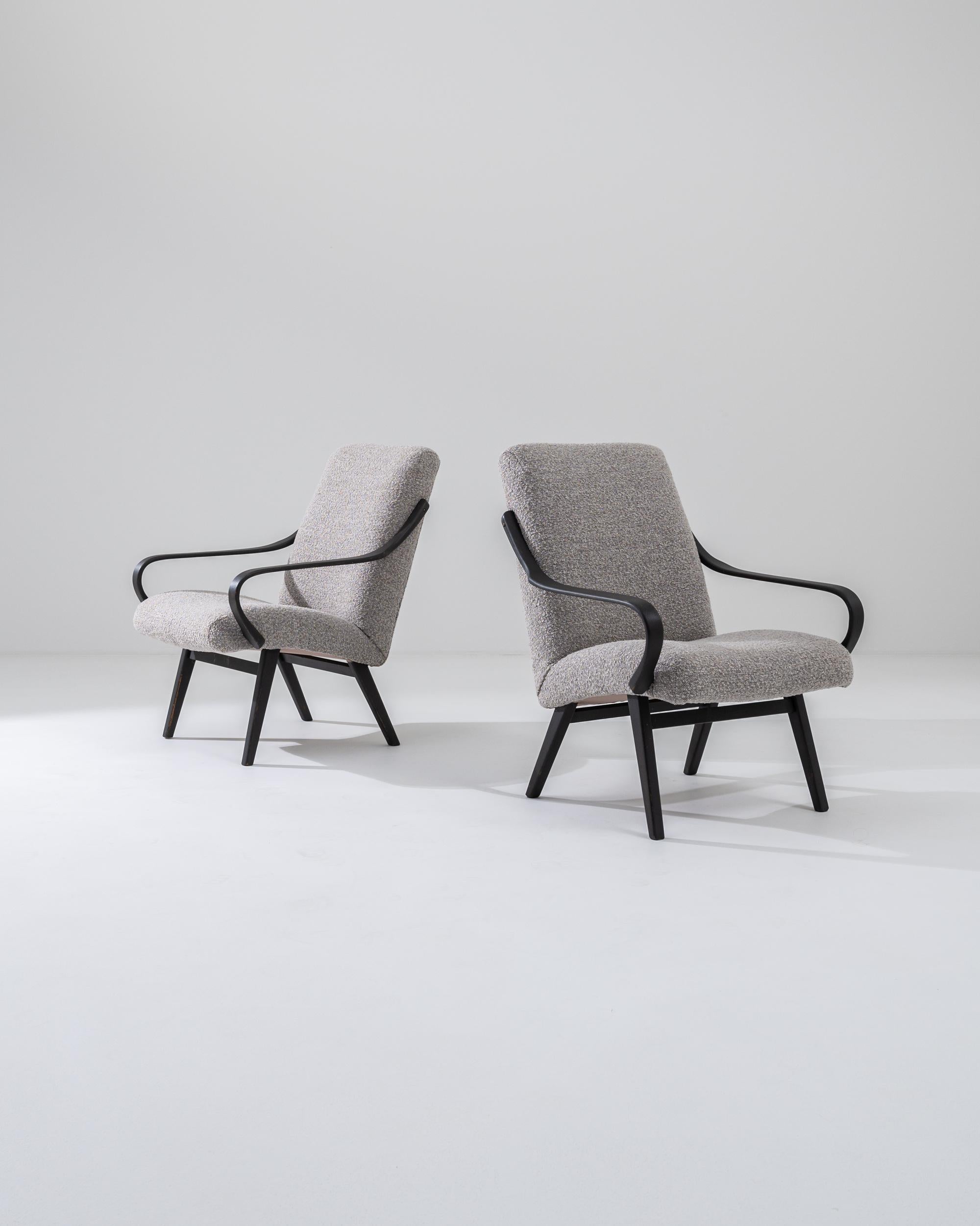 Ti presentiamo una sofisticata coppia di poltrone imbottite ceche degli anni '60, perfette per aggiungere un tocco di eleganza vintage a qualsiasi ambiente. Queste sedie sono caratterizzate da braccioli e gambe in legno nero graziosamente curvati,