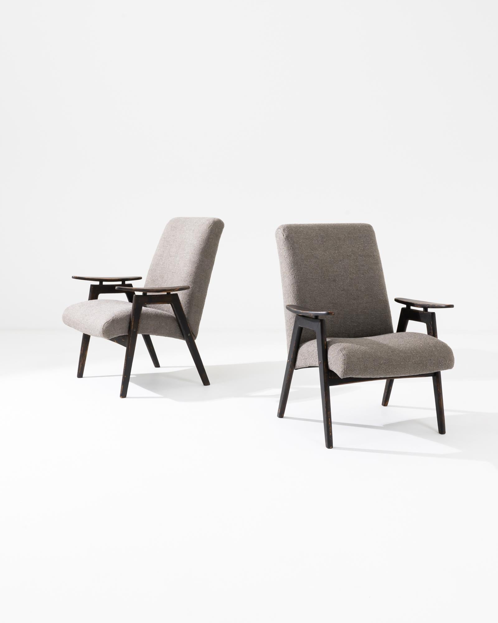 Eleva i tuoi interni con questa coppia di poltrone imbottite ceche degli anni '60, un esempio straordinario di design moderno di metà secolo. Queste sedie sono caratterizzate da strutture in legno eleganti e angolari con una finitura scura e ricca