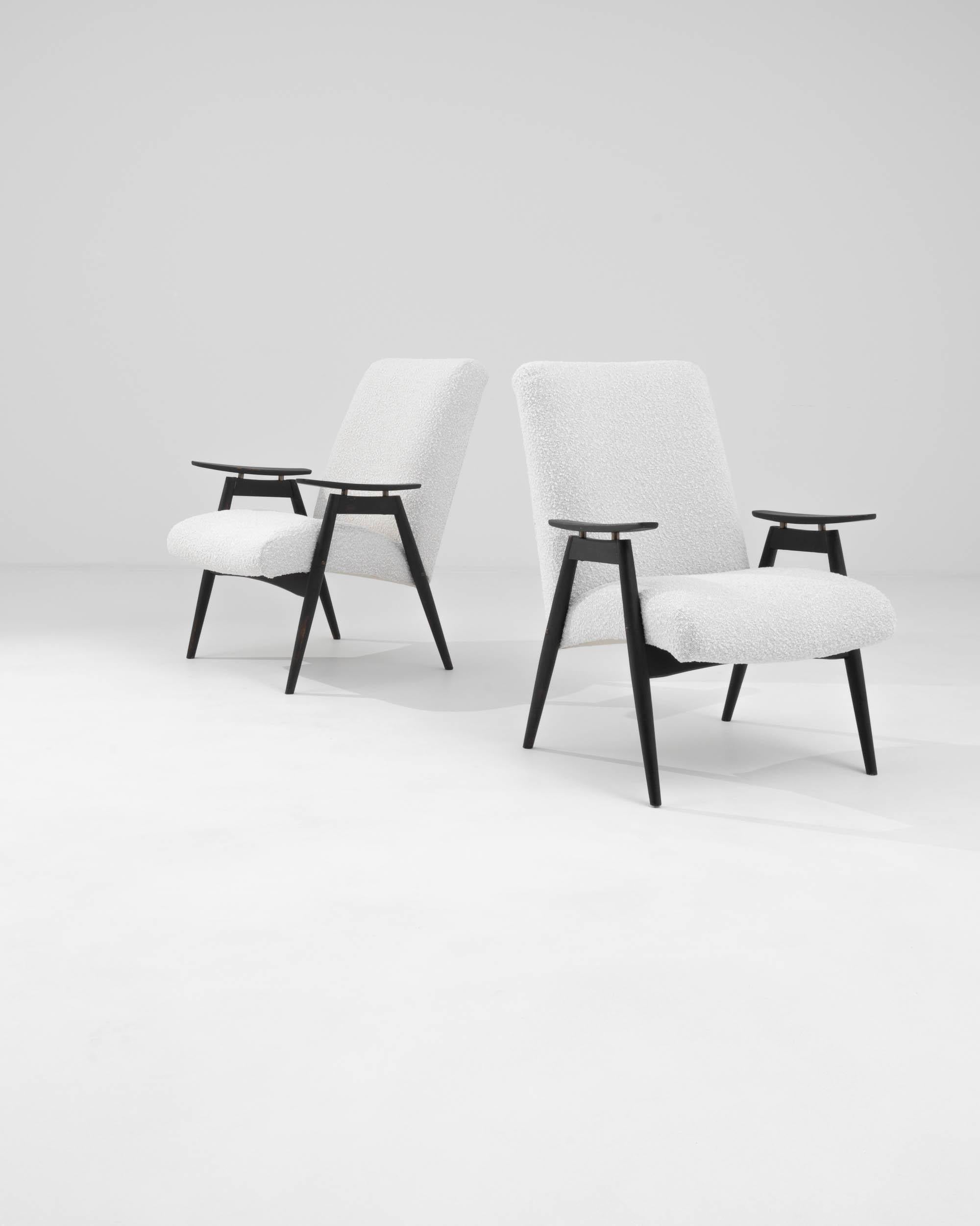 Voici une paire sophistiquée de fauteuils tapissés tchèques des années 1960 qui incarnent l'élégance moderne du milieu du siècle. Ces chaises sont dotées d'un cadre en bois noir qui contraste magnifiquement avec le revêtement blanc immaculé, créant