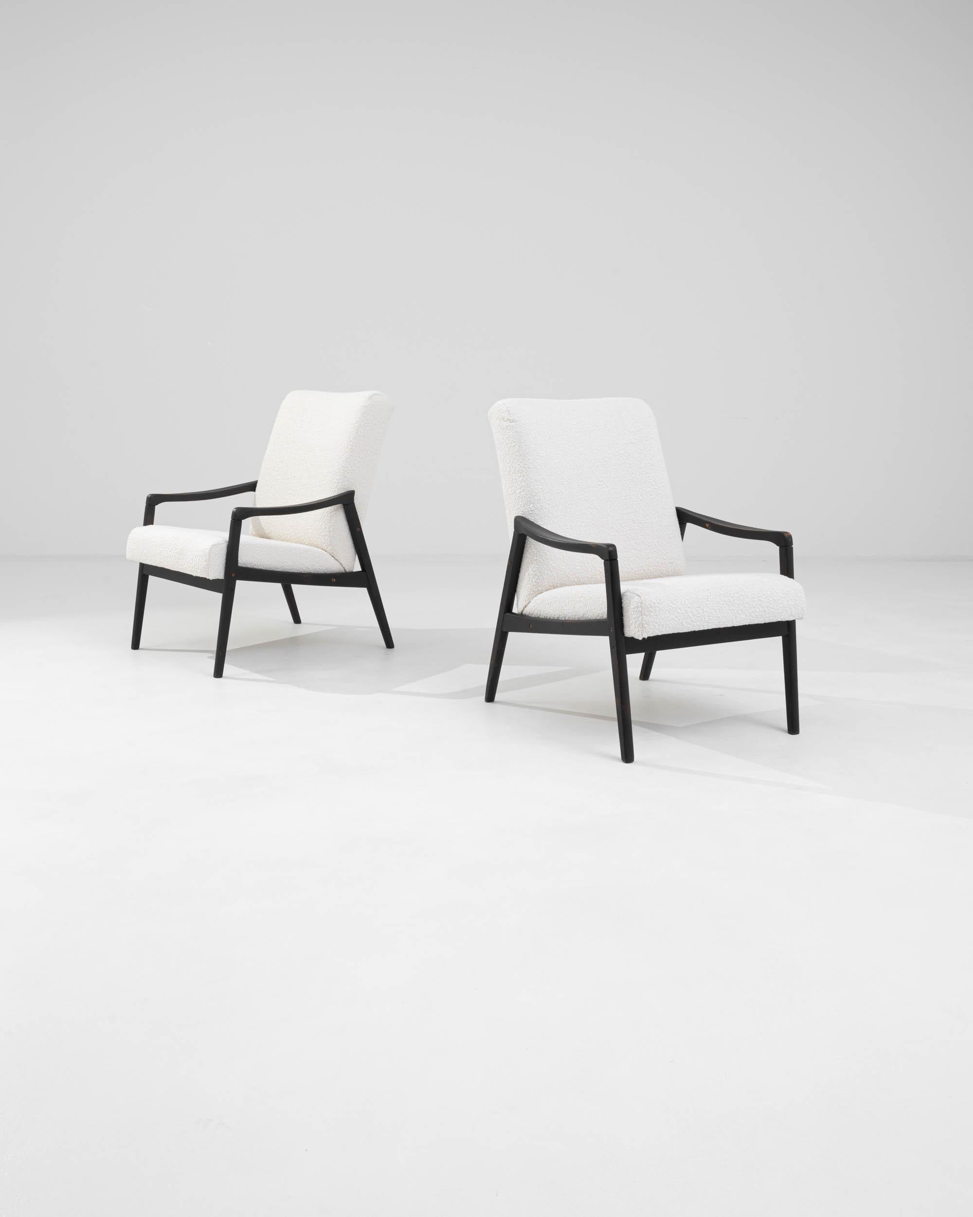 Voici une paire sophistiquée de fauteuils tapissés tchèques des années 1960, parfaits pour ajouter une touche d'élégance moderne du milieu du siècle à votre intérieur. Ces chaises sont dotées d'un élégant cadre en bois noir qui contraste