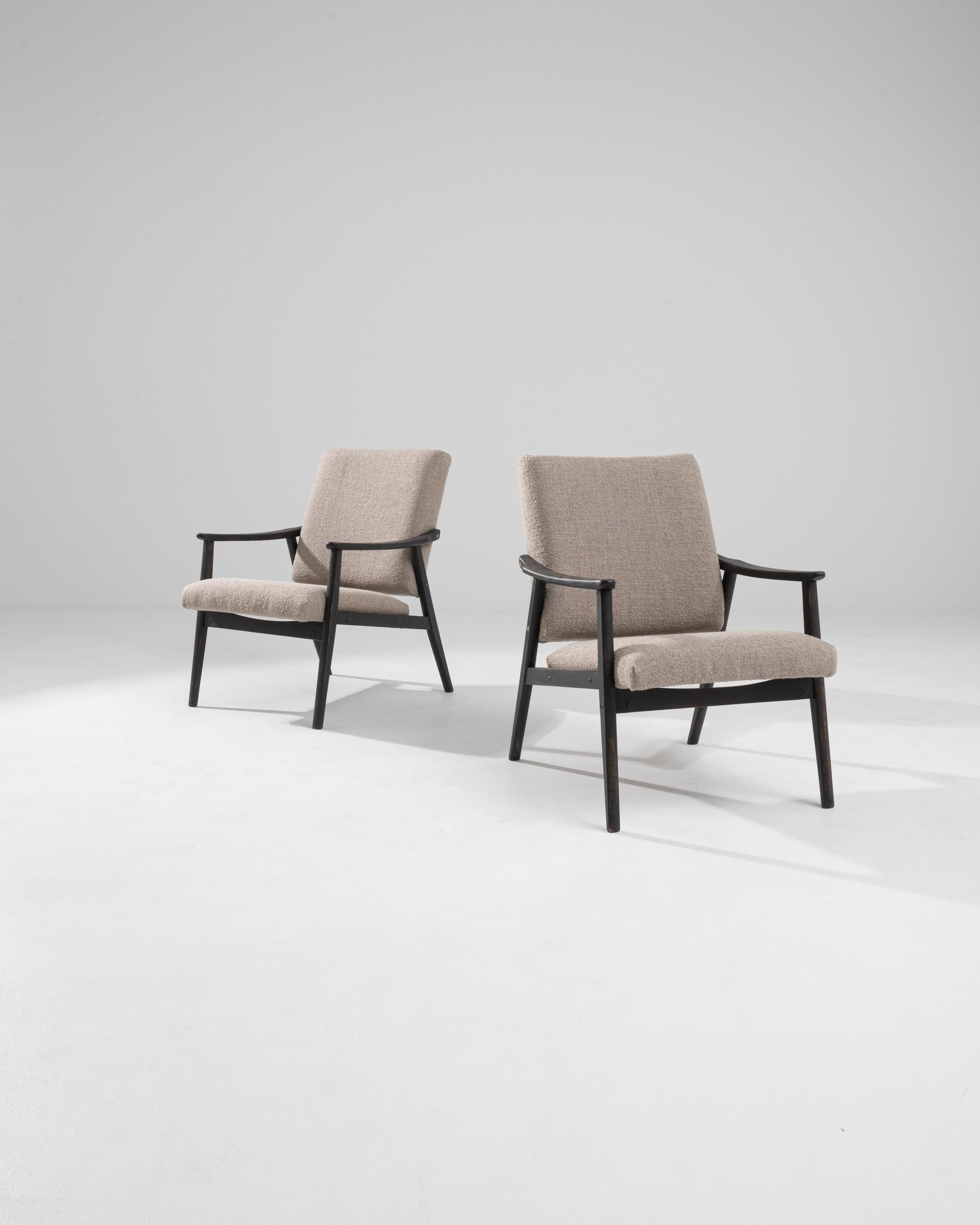 Ajoutez une touche de sophistication du milieu du siècle à votre intérieur avec cette paire de fauteuils tapissés tchèques des années 1960. Dotées d'un élégant cadre en bois noir, ces chaises offrent un contraste saisissant avec le rembourrage beige