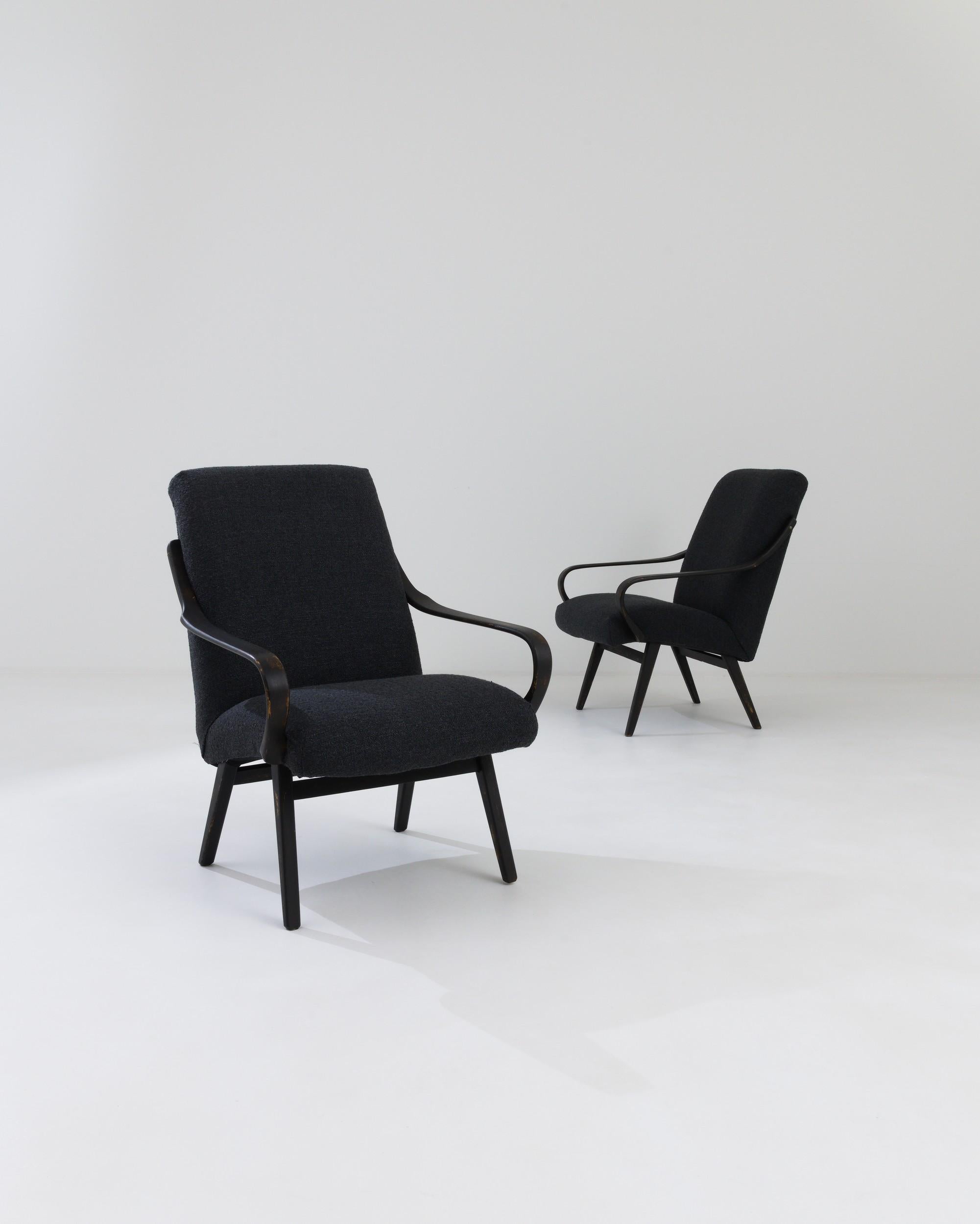 Eliciting a futuristic ambiance with their sleek, flowing contours, this pair of Czech armchairs was designed in the 1960s and produced by the illustrious firm, TON. The smoothly curved armrests engage in an aesthetic dialogue with the