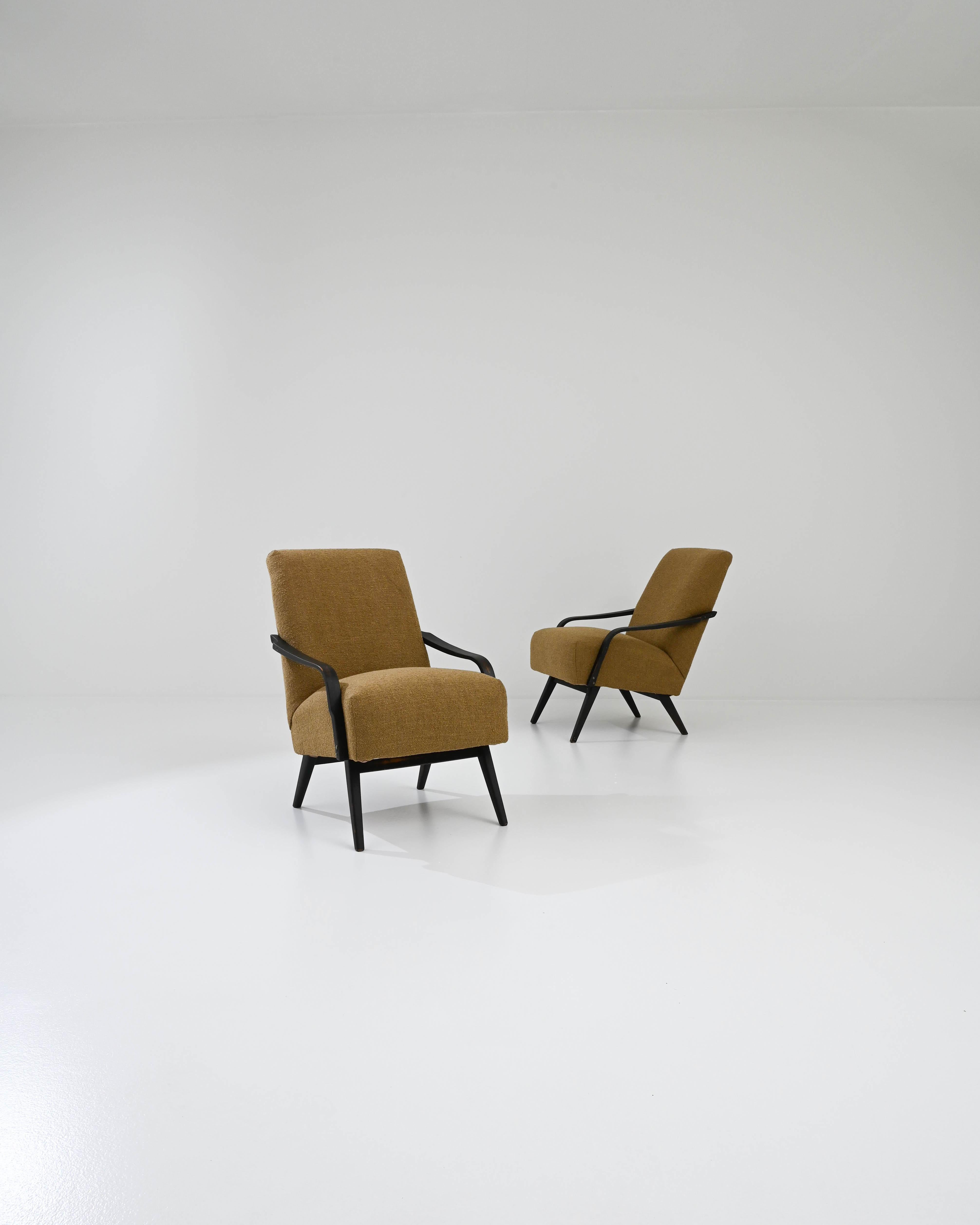 Designed and manufactured by the renowned TON furniture maker and lined in burnt caramel colors, this pair of vintage Mid-century modern chairs present an easy-going, yet sober accent. These curved bentwood armchairs invite you to spend leisure