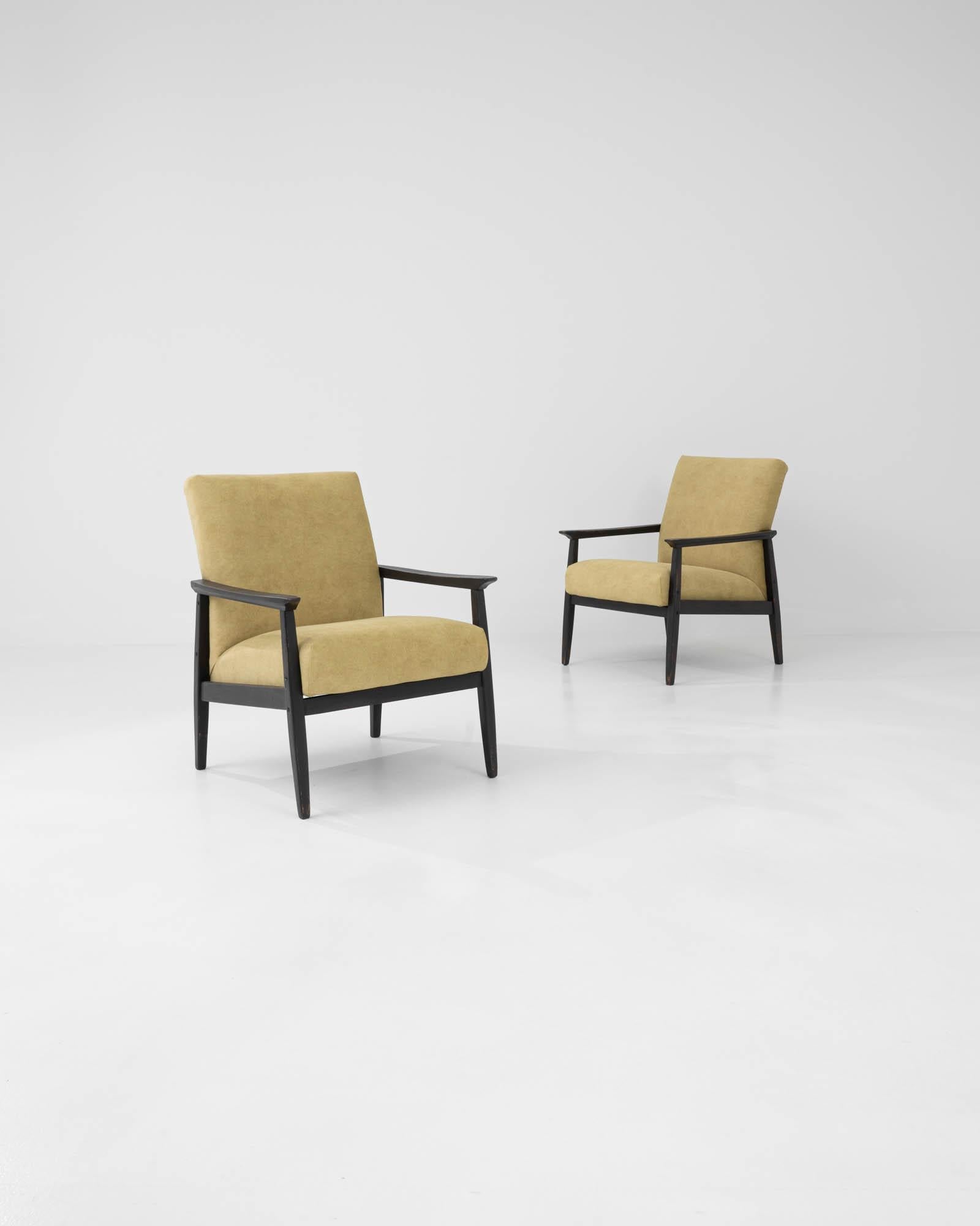 Graphic and sophisticated, this pair of vintage upholstered armchairs showcase the versatility and elegance of Central European Modernism. Made in Czechia in the 1960s, the frame combines clean angles and smooth curves for a bold yet inviting