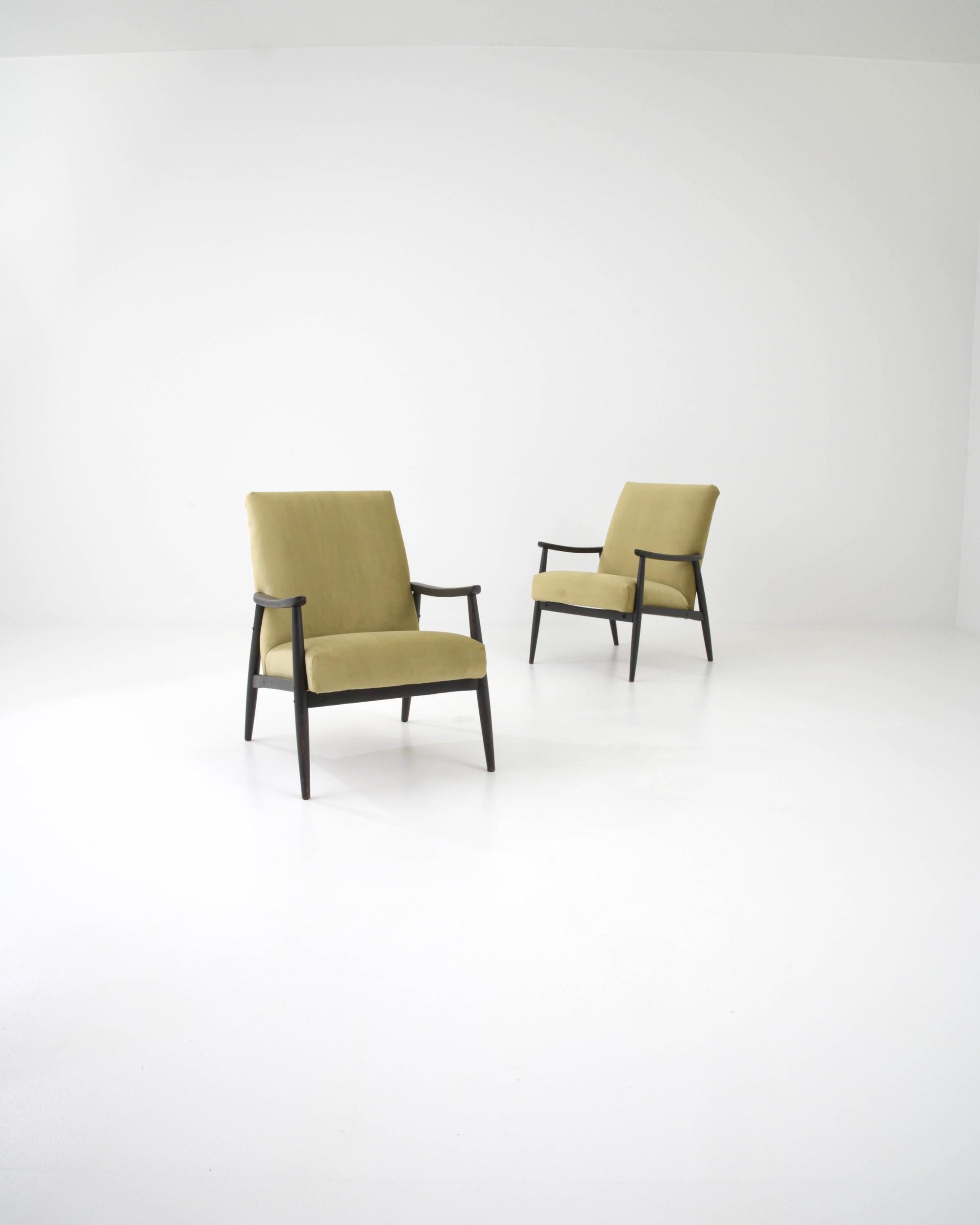 This pair of 1960s Czech armchairs provide the perfect nook in which to watch the world go by. The seat, generously cushioned and set at an inviting recline, seems to float like a cloud between the branches of the angular wooden frame. The velvety