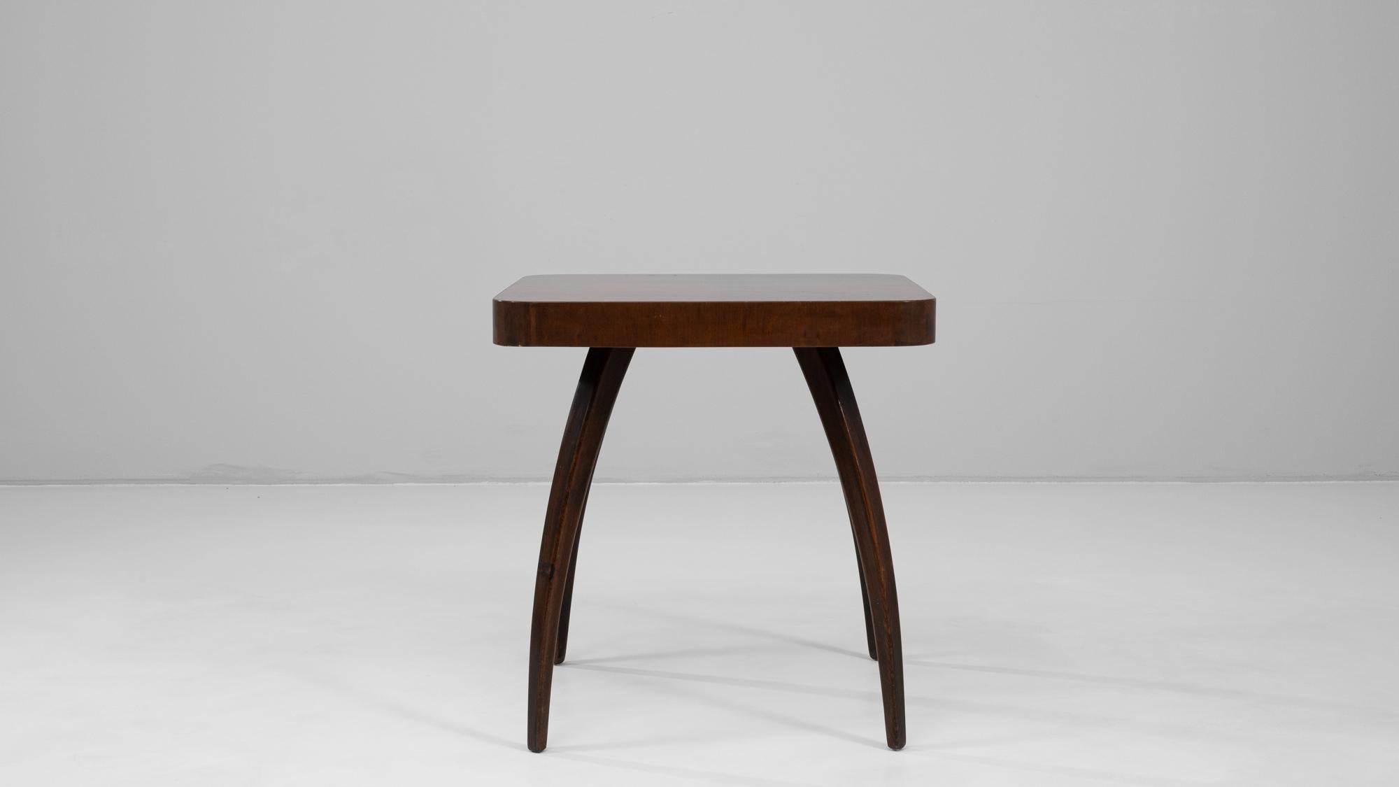 This 1960s Czech walnut spider table by renowned designer Jindřich Halabala exemplifies his innovative approach to modernist furniture design. The table’s sculptural silhouette features four elegantly curved legs that extend outward from the center,