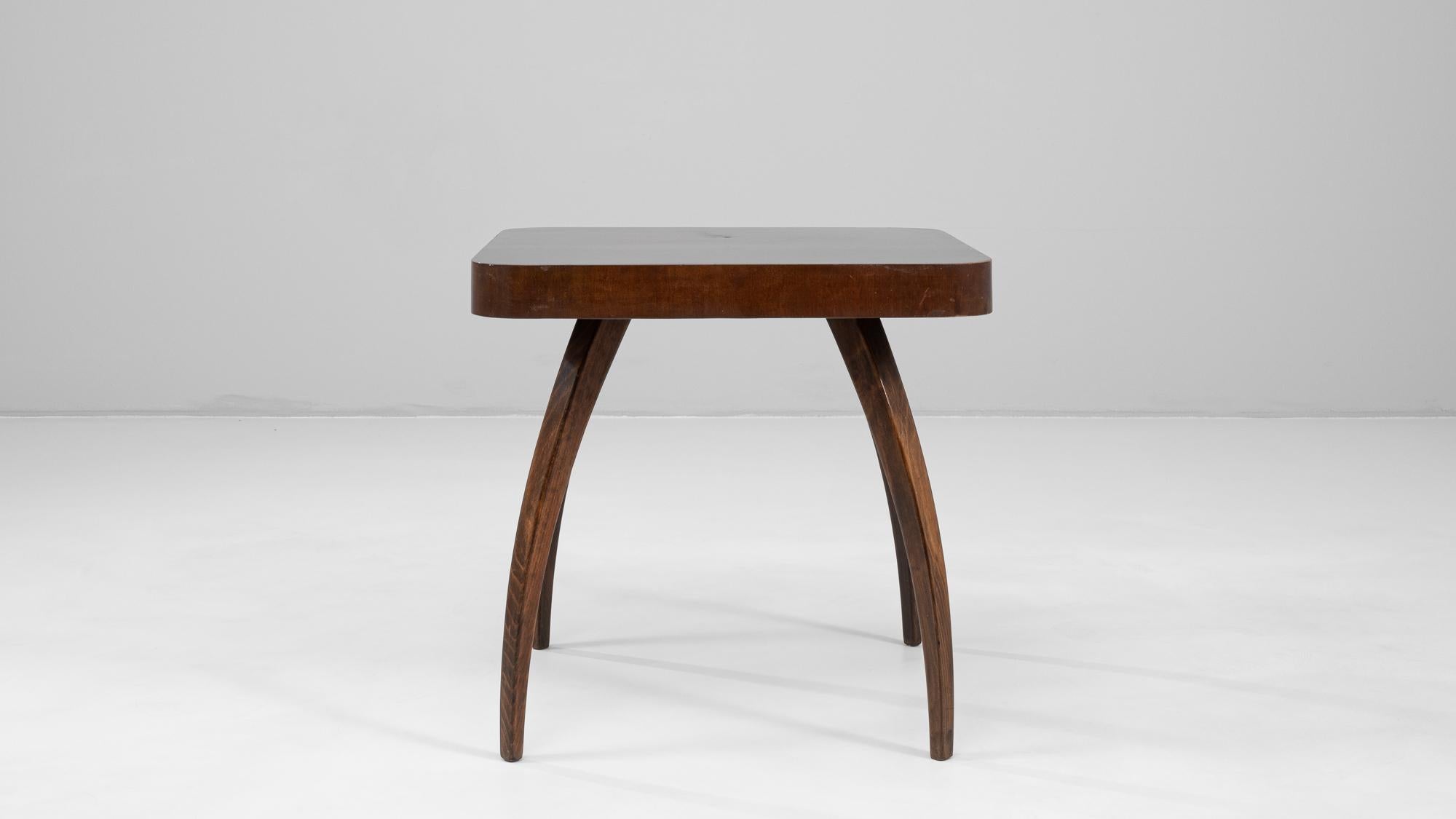 This 1960s Czech walnut spider table by renowned designer Jindřich Halabala exemplifies his innovative approach to modernist furniture design. The table’s sculptural silhouette features four elegantly curved legs that extend outward from the center,