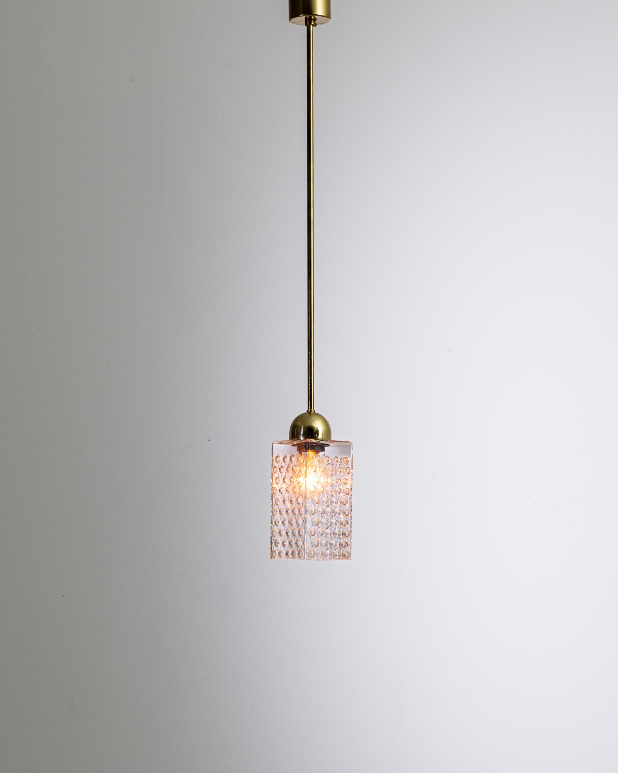 Illuminate your space with the classic sophistication of our 1960s Czech White Brass and Glass Pendant Lamp. This striking piece embodies the innovation of mid-century design, combining the lustrous warmth of a polished brass stem with the textured