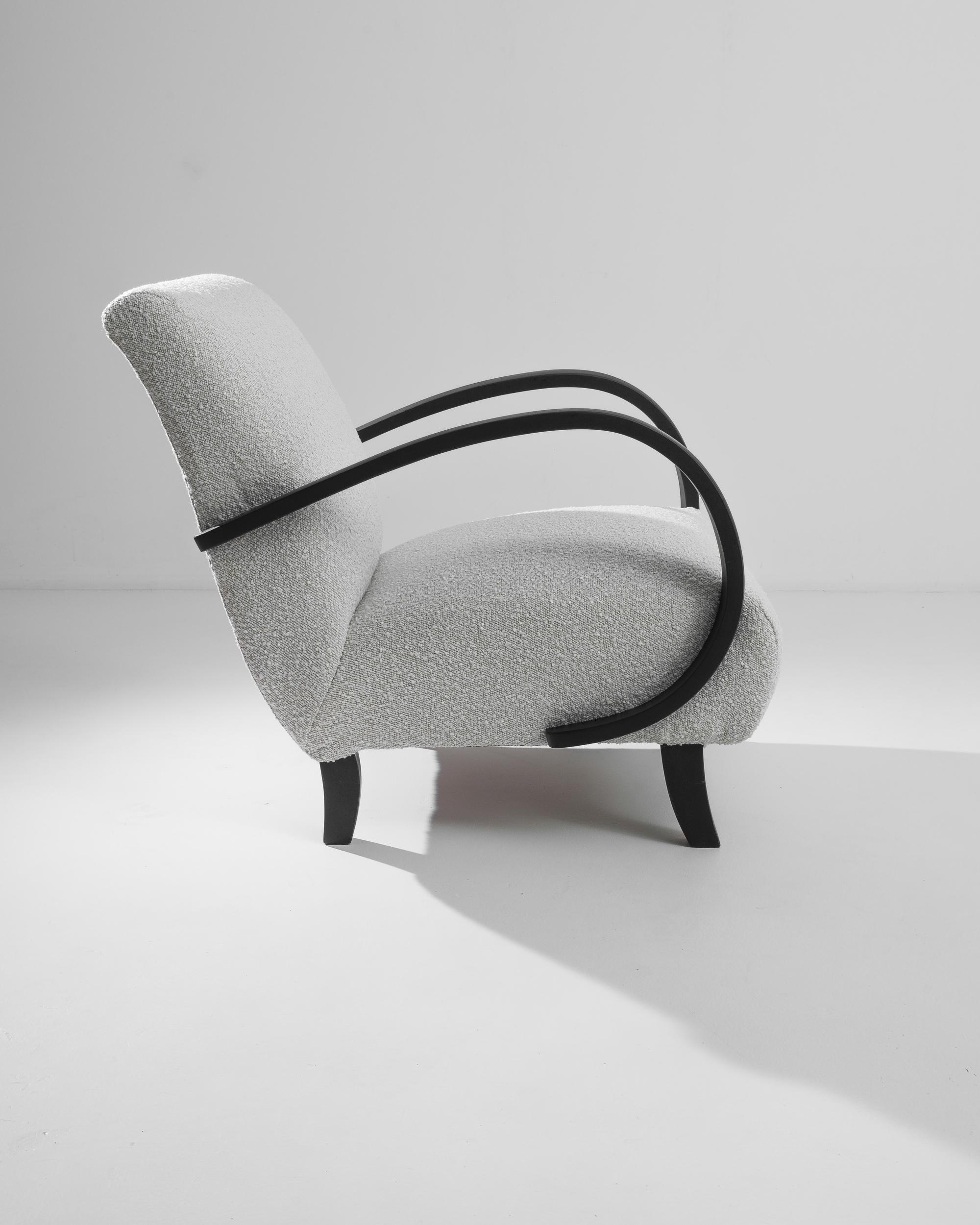 Discover the elegance of the 1960s Czech Wooden Armchair by the legendary J. Halabala. This mid-century marvel features beautifully curved black wooden arms that effortlessly complement its sleek design. The chair's plush, textured upholstery