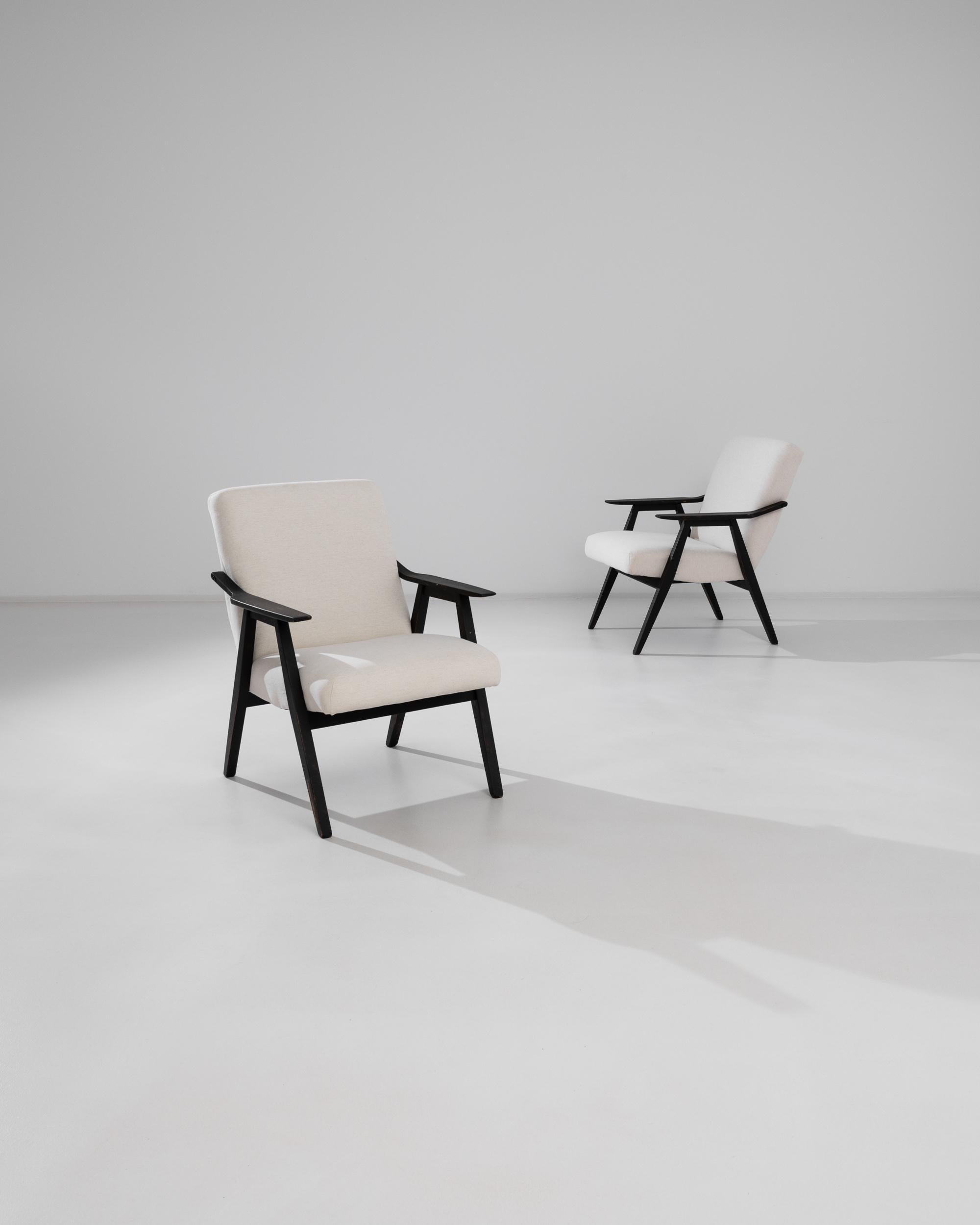 Cette paire de fauteuils en bois tchèque des années 1960 offre un mélange parfait de design du milieu du siècle et de confort moderne. Les chaises sont dotées d'accoudoirs en bois gracieusement courbés dans une finition riche et sombre, contrastant