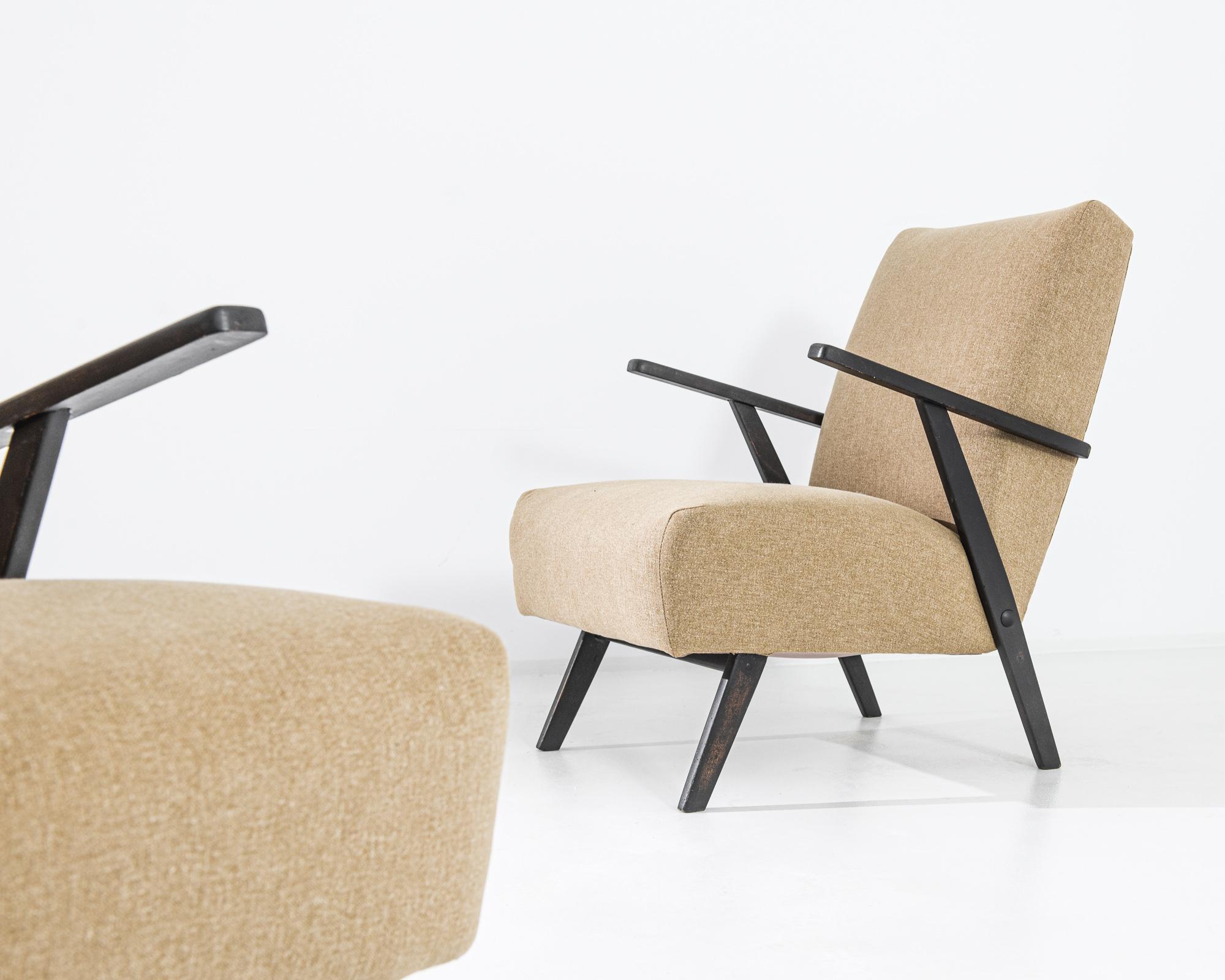 Immerse yourself in the mid-century allure with a set of two 1960s Czechia Wooden Armchairs. Upholstered in a timeless beige, these chairs exude elegance, while the sleek black arms and legs provide a striking contrast. Crafted with meticulous