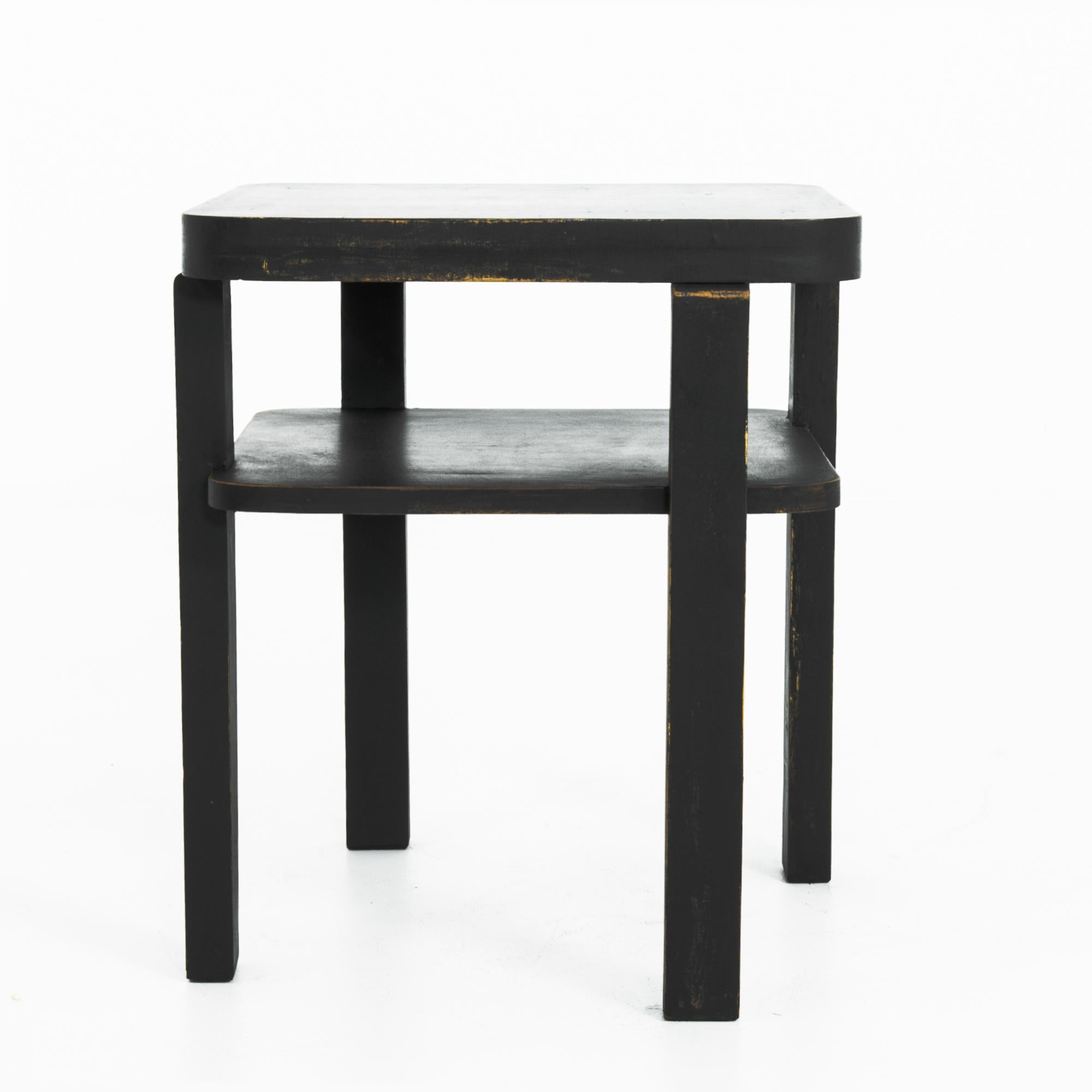A glass topped wooden table from Czechia, circa 1930. With a Modernist era provenance, this piece delivers a subtle sleek simplicity, elegantly aged in black, giving a sleek inflection. Modern yet homey, the design has an attractive simplicity.