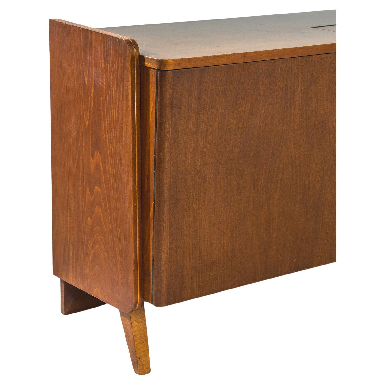 In the dynamic design landscape of 1960s Czechoslovakia, Tatra Furniture Company emerged as a hallmark of innovation and craftsmanship. This wooden sideboard, crafted by Tatra during that era, epitomizes the company's commitment to sleek modern