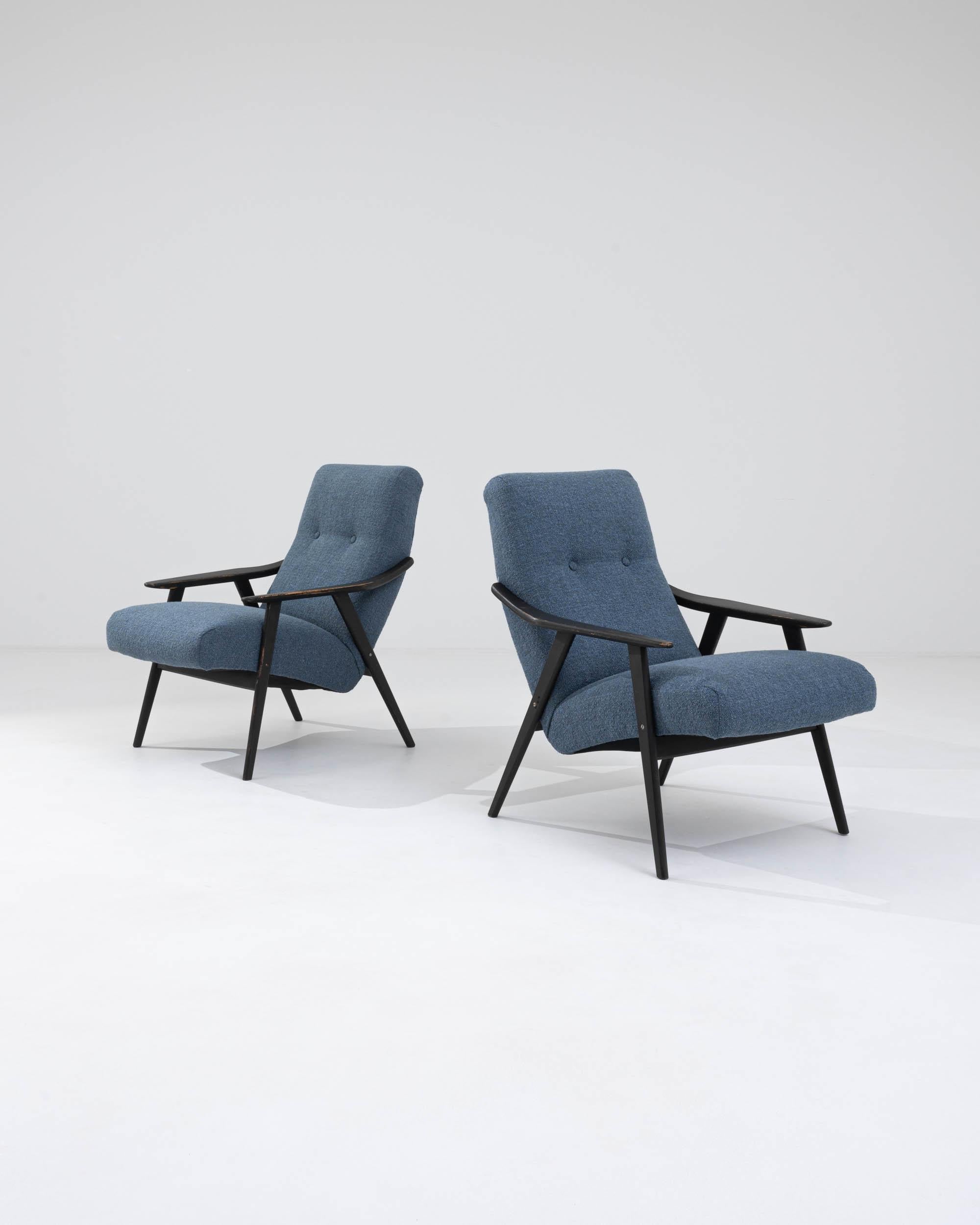 Step back into the charm of the 1960s with this exquisite pair of Czech Wooden Upholstered Armchairs, embodying the era's love for minimalist design and functional comfort. The sleek, angular wooden frames, finished in a deep, rich hue, offer a