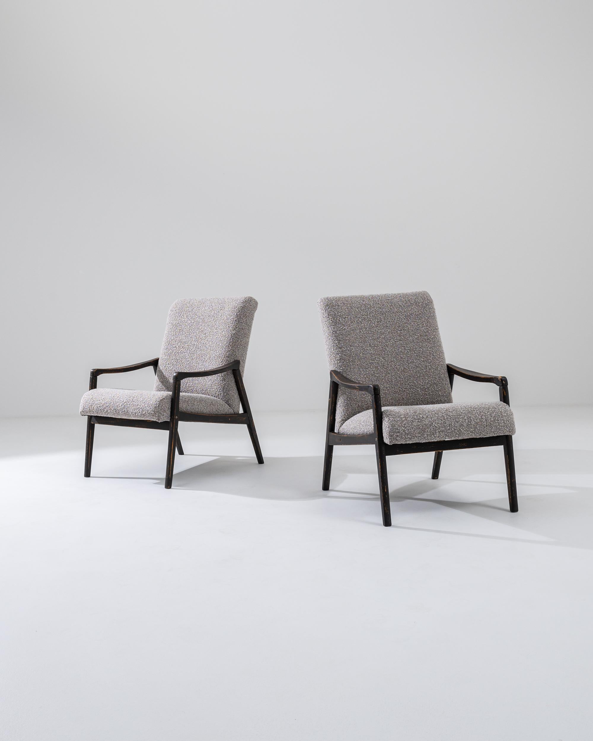 A pair of armchairs produced in the former Czechoslovakia, with the design attributed to Jiri Jiroutek. This 1960s design is re-upholstered in an updated taupe bouclé upholstery; the neutral tone was chosen to compliment the polished patina of the