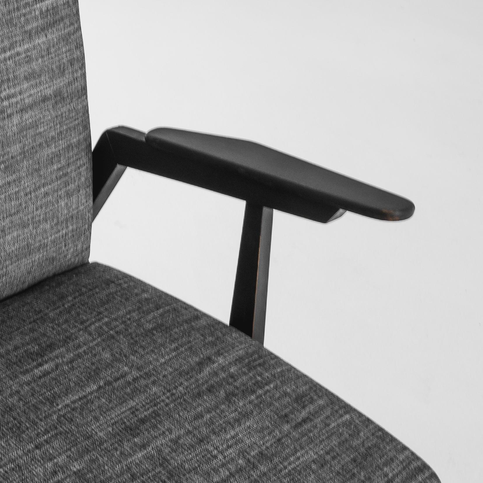 This pair of 1960s Czech armchairs embodies the sleek and minimalistic charm of mid-century design. Crafted with a sturdy wooden frame in a deep, almost black finish, these chairs stand out with their angular lines and gently tapered legs. The