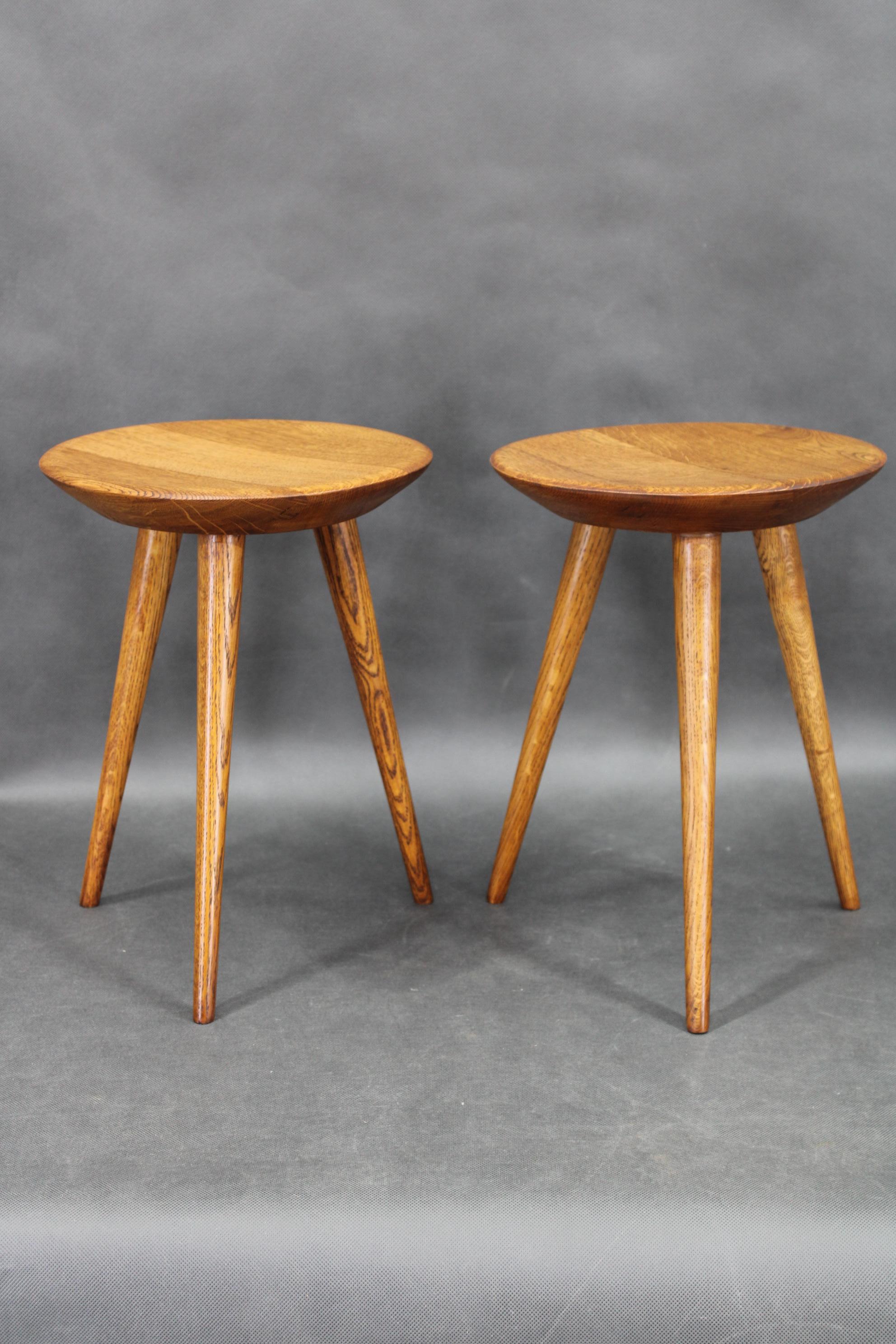 This pair of mid-century oak tripod stools was produced in 1960s Czechoslovakia by ÚLUV, an organization known for promoting traditional craftsmanship and high-quality handmade design. Each stool features a round wooden seat supported by three