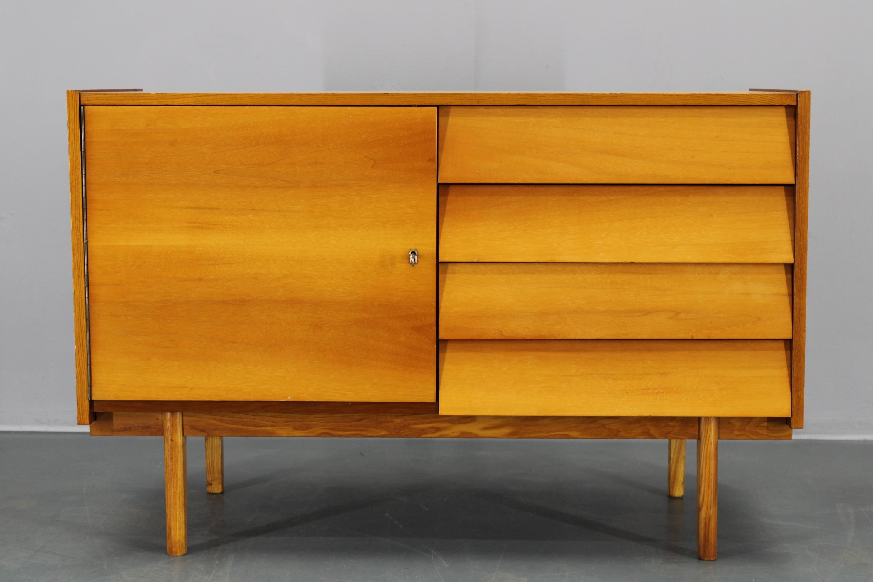 Vintage sideboard made in Czechoslovakia circa 1960s, crafted from maple veneer and solid maple wood. This highly functional mid-century piece features a lockable door on the left and four spacious drawers on the right, all presented with a stunning