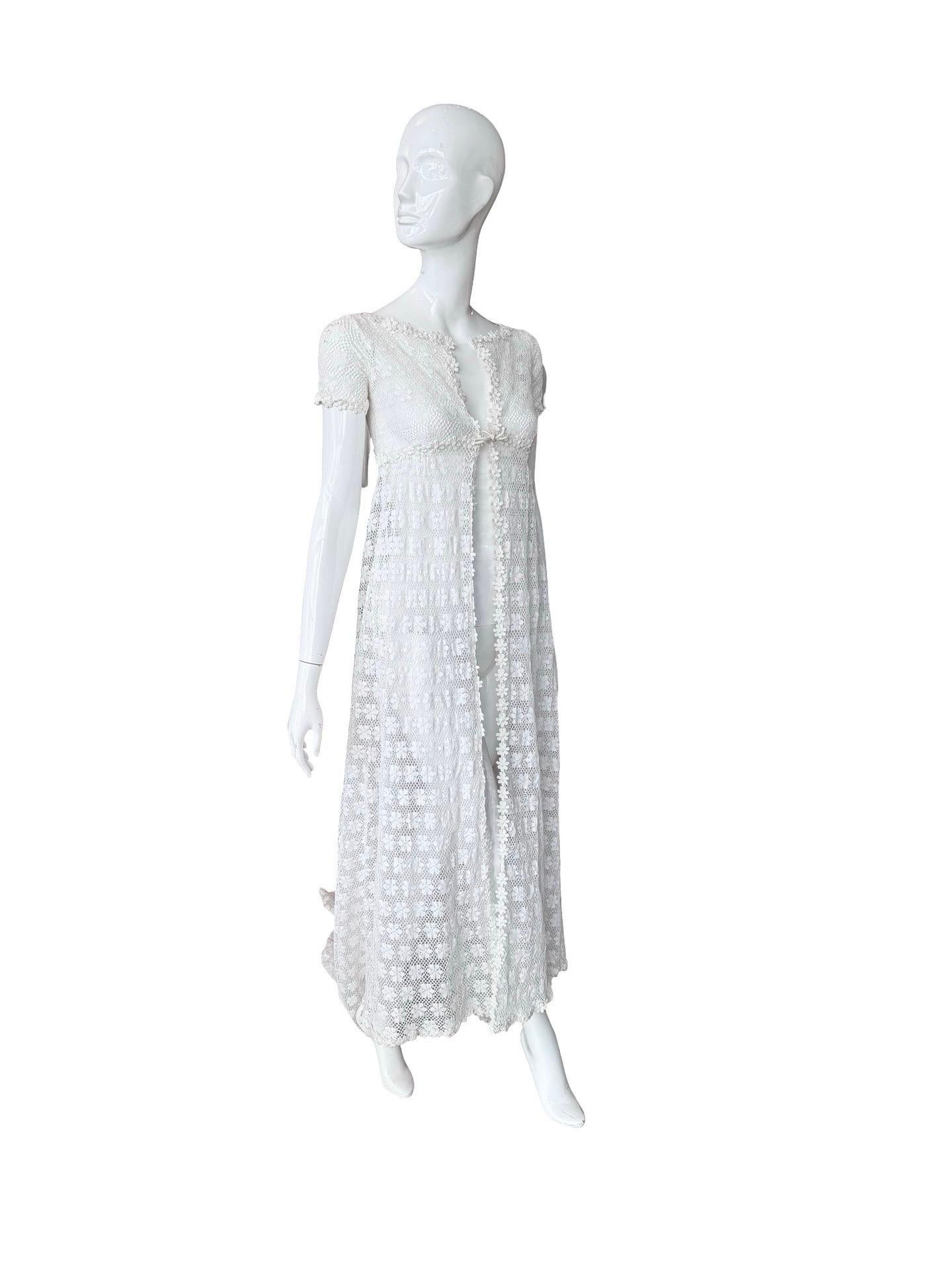Stunning white daisy lace short sleeve capelet with an empire fit and a long wide train.  It's in great condition.  If it's too small in the shoulders it could also be tailored to turn it into just a cape without the sleeves.  Such a unique piece to