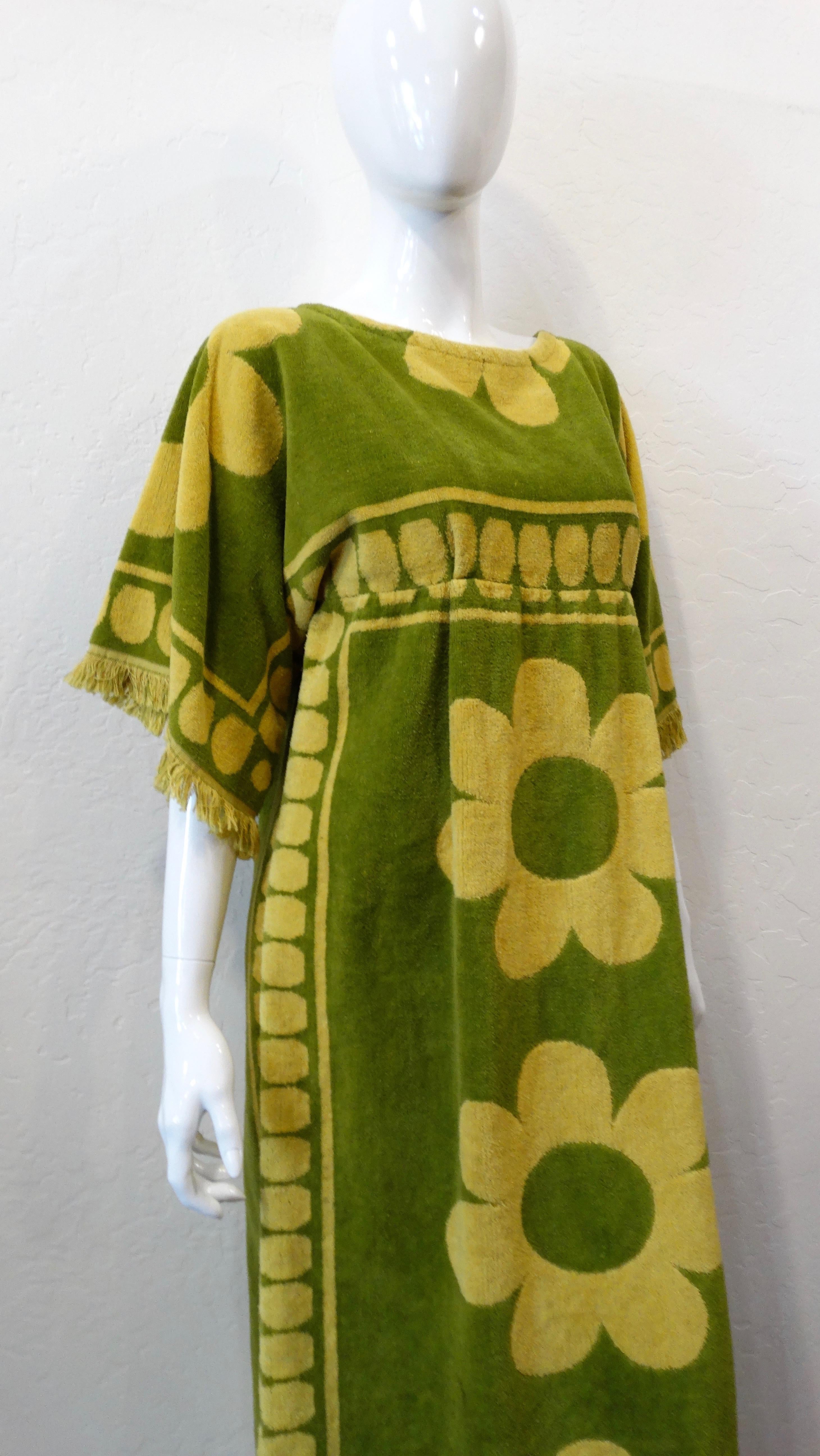 Feel all the flower power with this adorable towel dress! Circa 1960s, this maxi length towel dress is made of light olive green terry cloth and features a contrasting chartreuse polka dot and large daisy pattern. Includes a frayed trim, an empire
