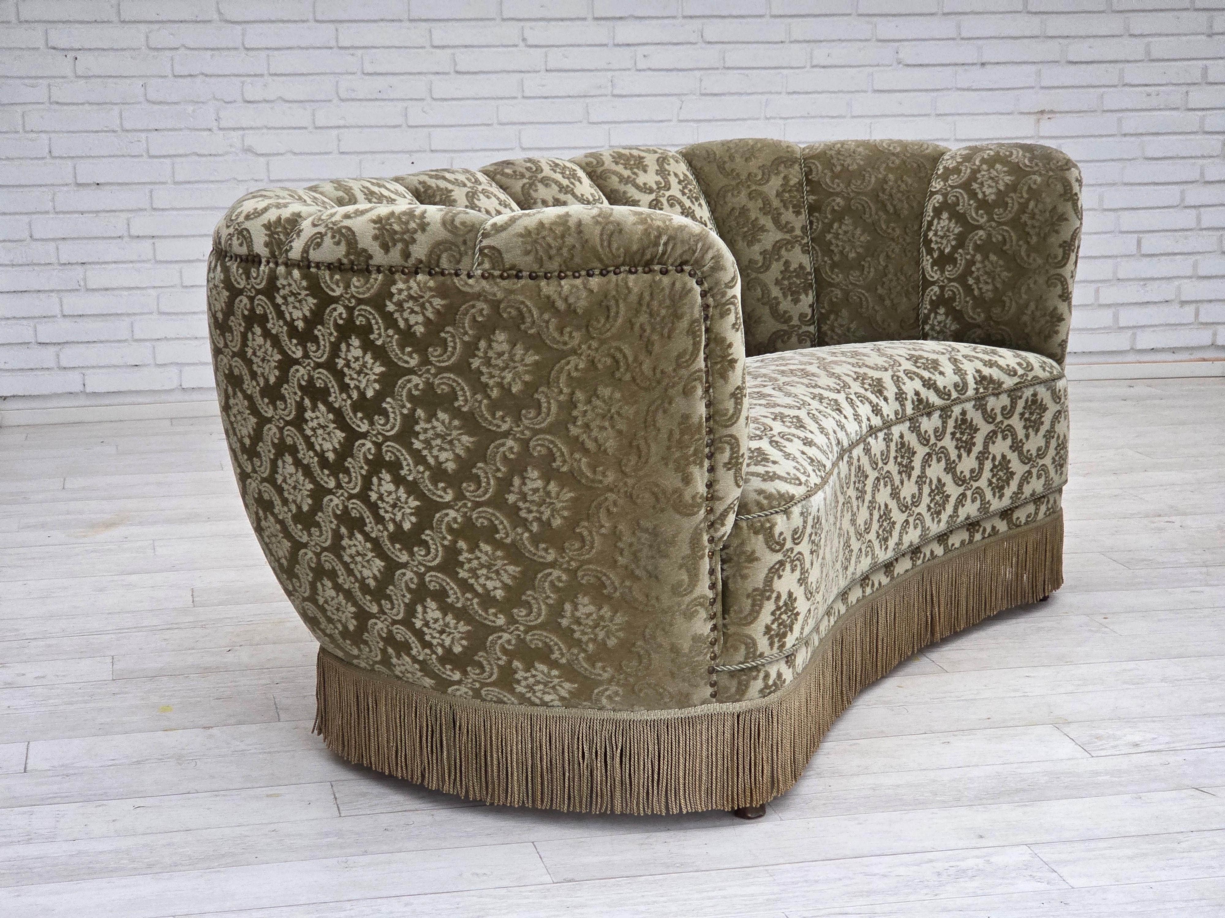 1960s, Danish 2-seater curved sofa. Velours d'ameublement vert clair d'origine, pieds en hêtre avec bouchons en laiton, ressorts en laiton. Bon état d'origine : pas d'odeurs, pas de taches et construction stable. Fabriqué par un fabricant de meubles