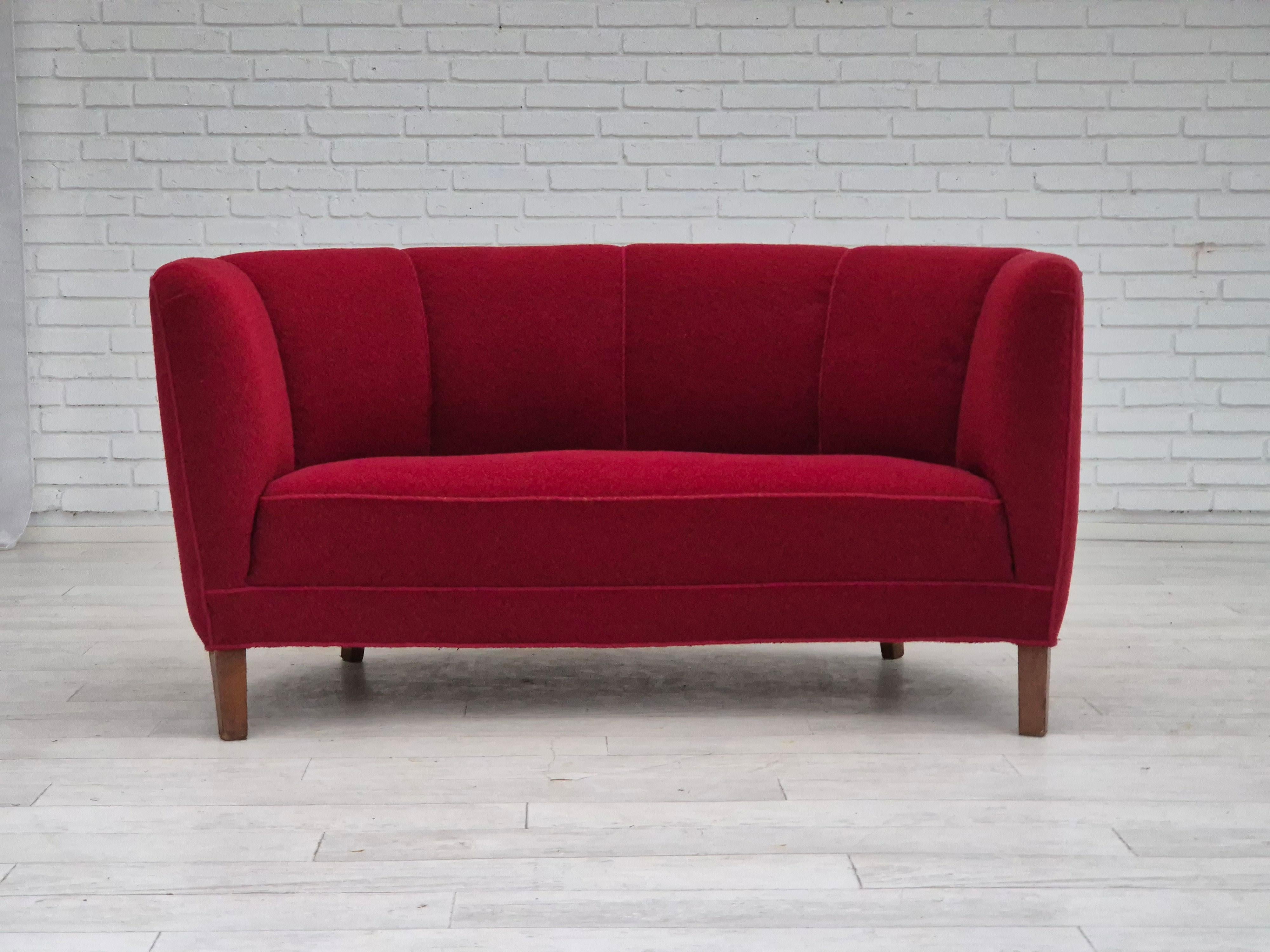 Divano danese a 2 posti curvo degli anni '60. Condizioni originali molto buone: nessun odore, nessuna macchia e struttura stabile. Tessuto originale rosso, gambe in legno di faggio, molle in ottone nella seduta. Prodotto da un produttore di mobili