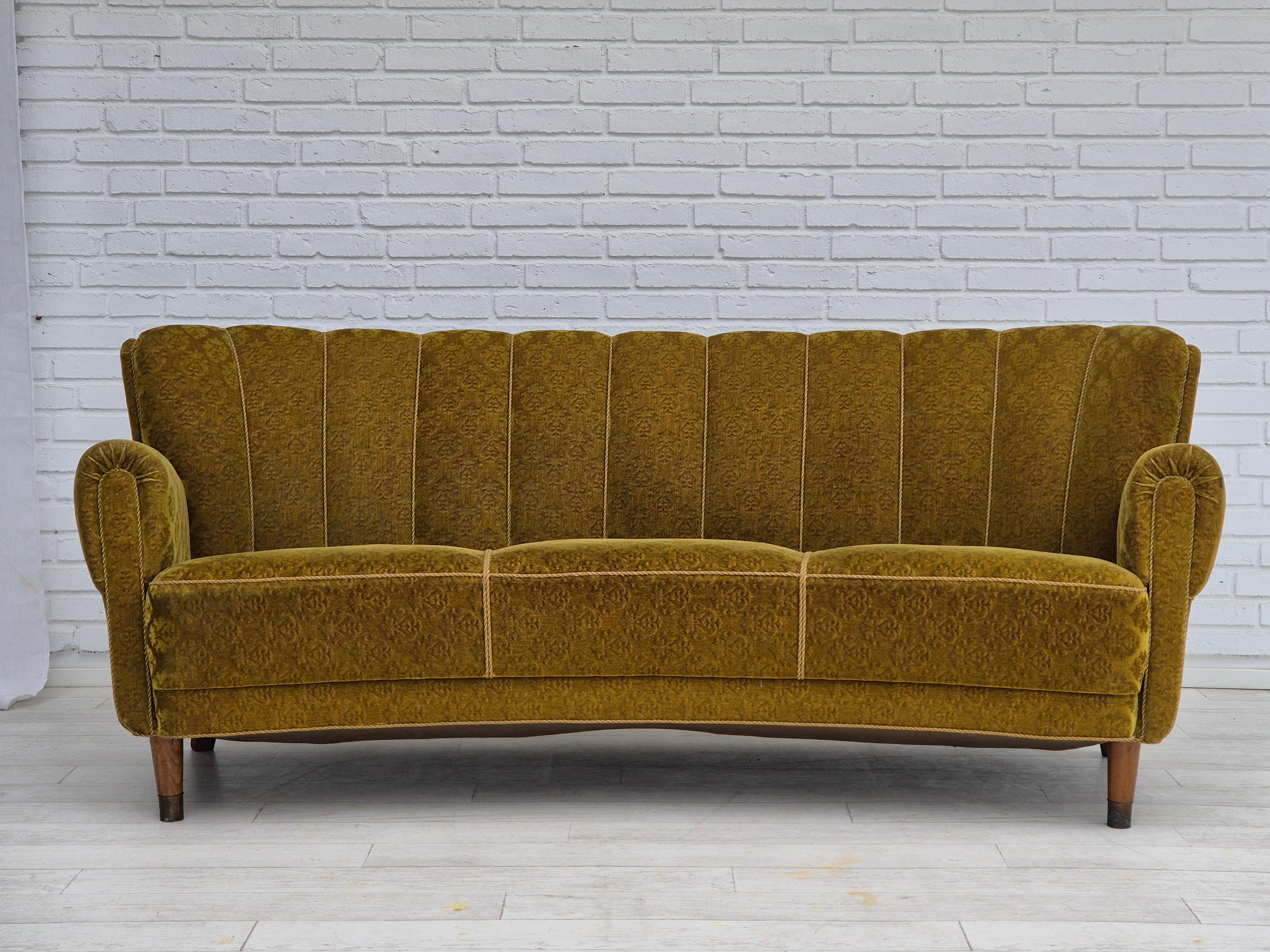 1960s, Danish 3 seater curved sofa in original very good condition: no smells and no stains. Original green furniture velour, beech wood legs with brass plugs. Brass springs in the seat. Manufactured by Danish furniture manufacturer in about