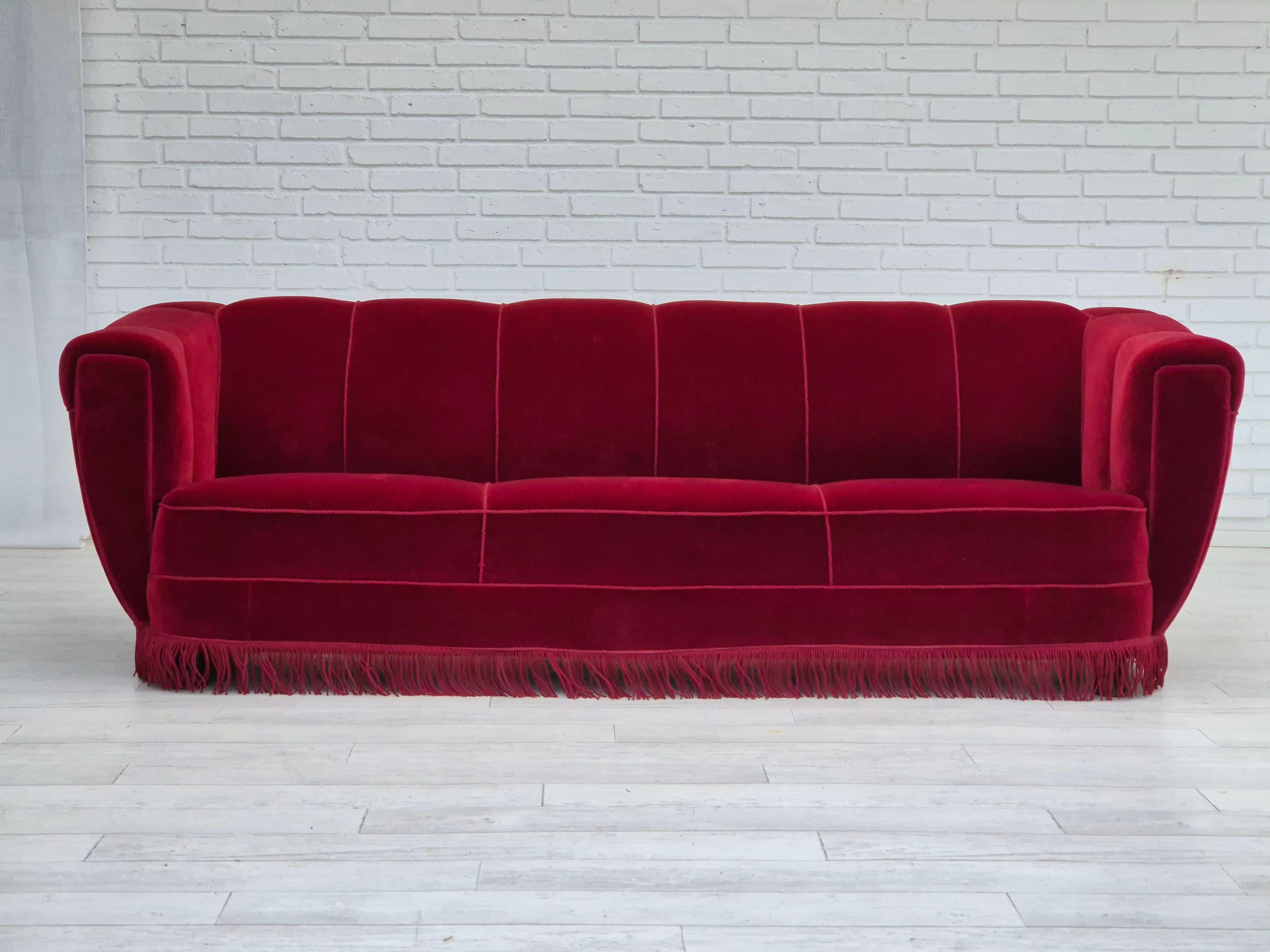 1960s, Danish 3 seater sofa in original very good condition: no smells and no stains. Cherry-red furniture velour, oak wood legs. Springs in the seat. Manufactured by Danish furniture manufacturer in about 1960s.