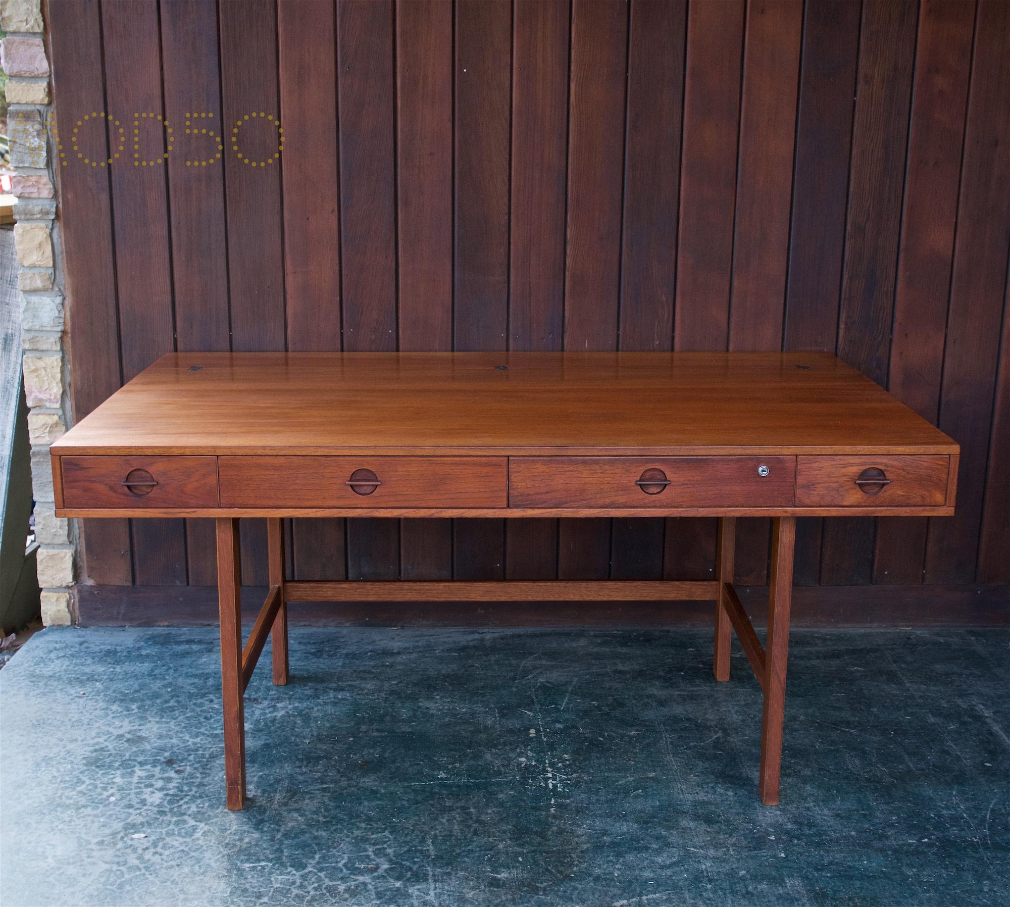 Wonderful dark hued teak desk, fully functional, but heavily patinated. Designed by Peter Løvig Nielsen, this ingenious desk has a shelf that flips, creating a flat work surface. Ideal as a shared desk for studio or office. Full surface measures: