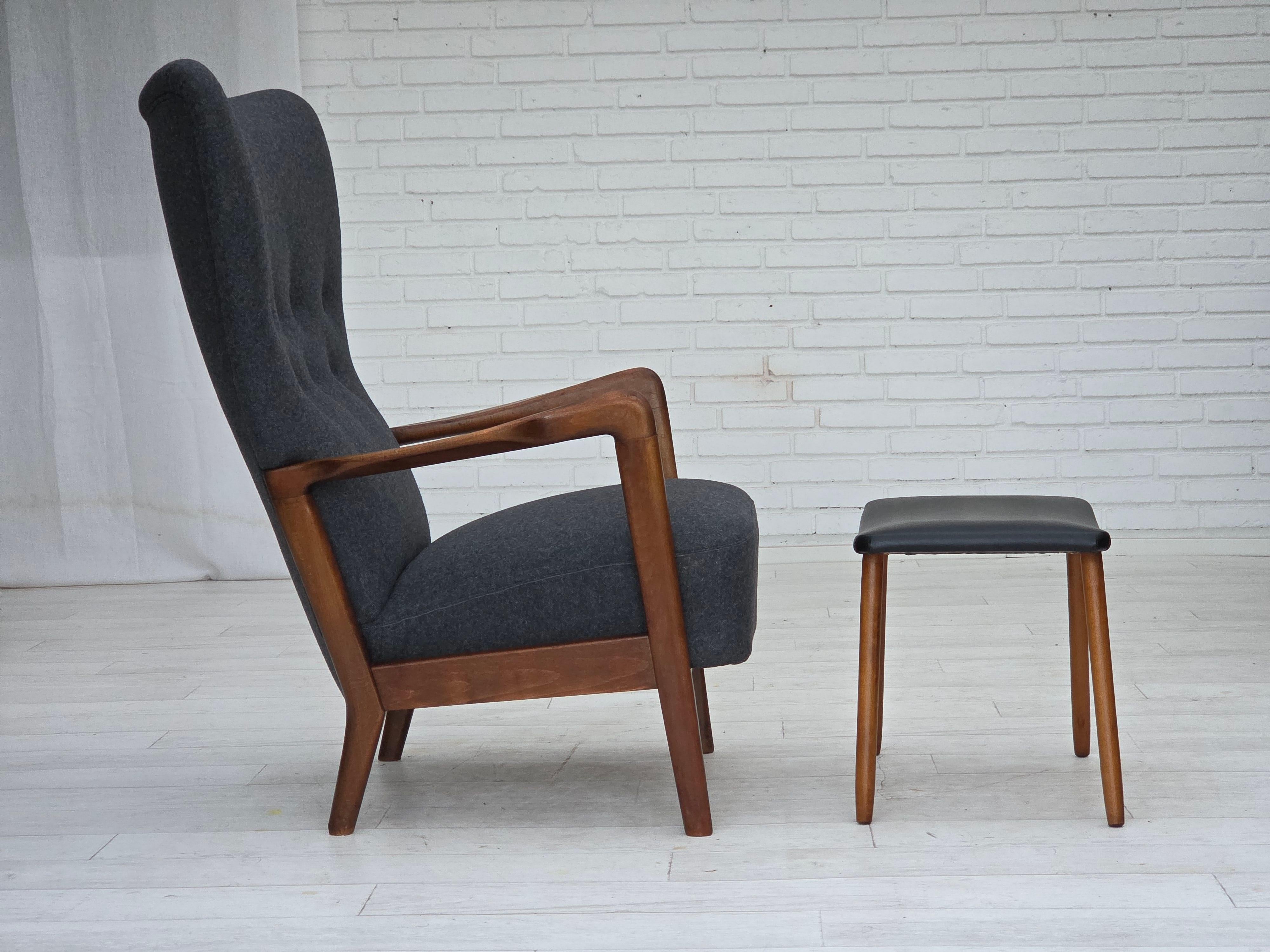 Fauteuil danois à dossier haut des années 1960, modèle 8000/8020 de Fritz Hansen. Rembourré en laine d'ameublement gris foncé de qualité. Bois de Beeche renouvelé, ressorts de l'assise et du dossier conservés. Boutons et tabouret en cuir artificiel