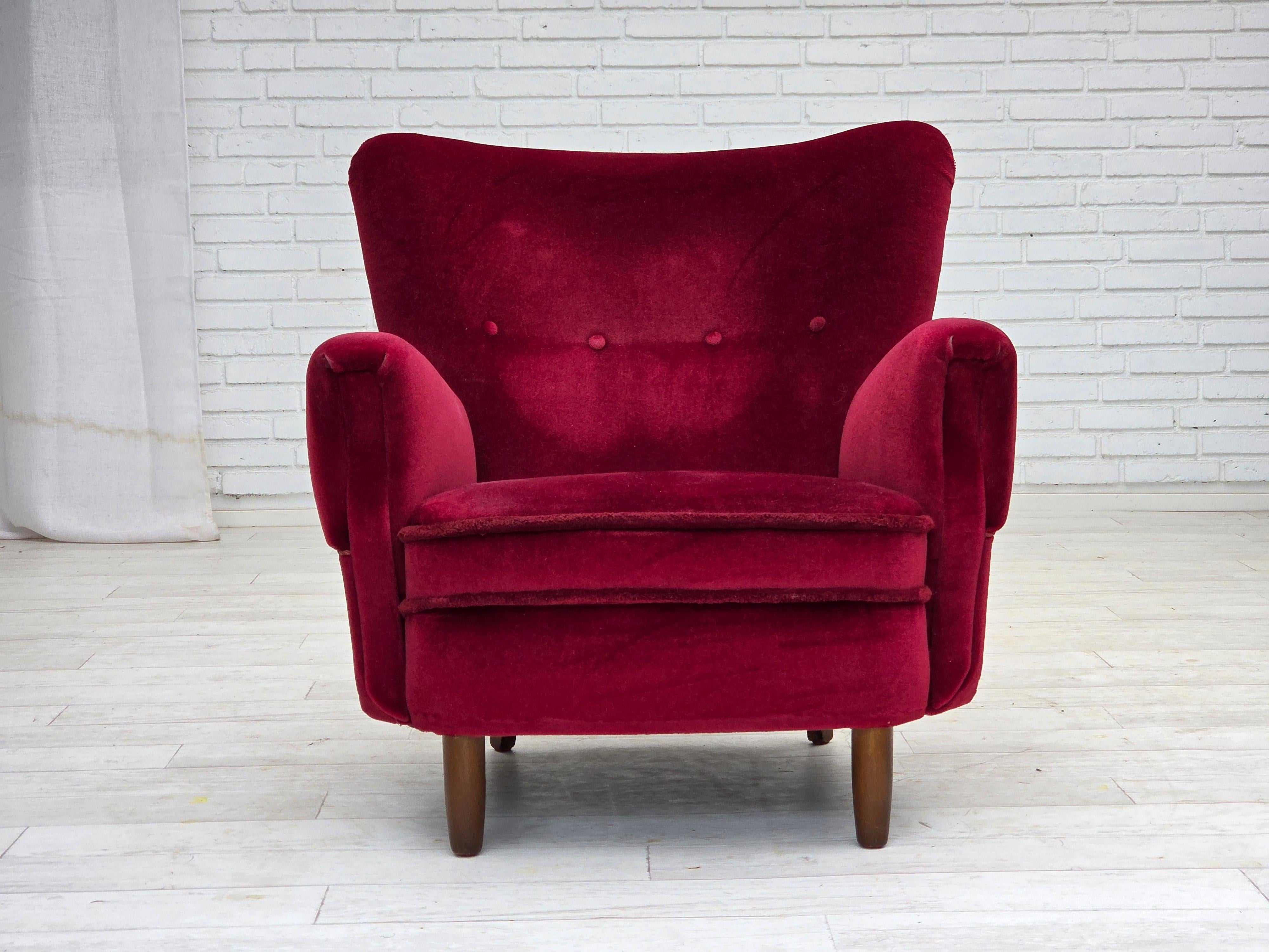 1960, Poltrona danese. Velluto originale rosso ciliegia, gambe in legno di faggio, molle in ottone nella seduta. Condizioni originali buone: nessun odore, nessuna macchia e struttura stabile. Prodotto da un produttore di mobili danese intorno agli