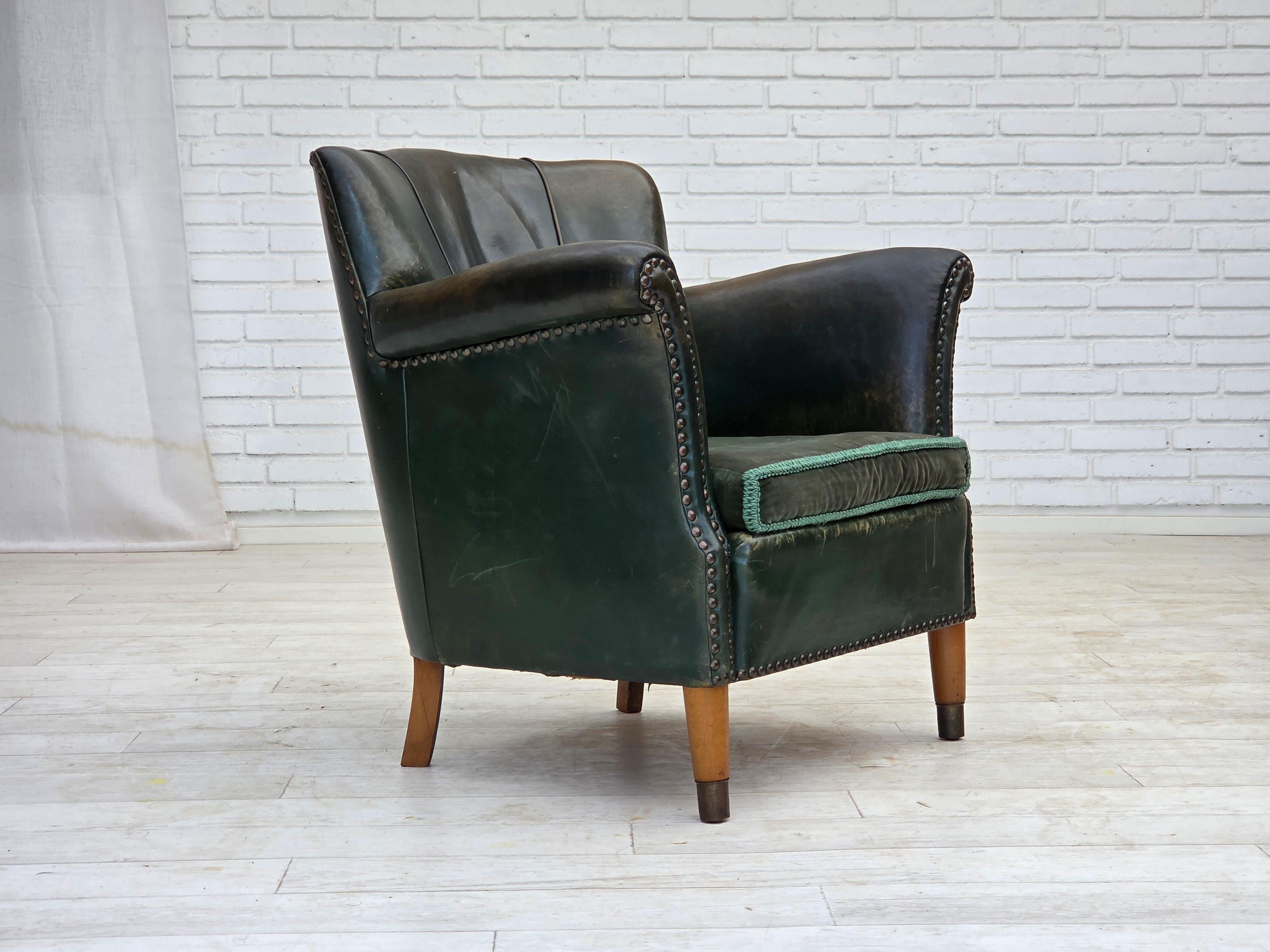 1960s, fauteuil danois. Cuir d'ameublement original vert foncé patiné, velours d'ameublement vert foncé, pieds en bois de hêtre avec fiches en laiton. Ressorts en laiton dans le siège. Bon état d'origine : pas d'odeurs, pas de taches et construction