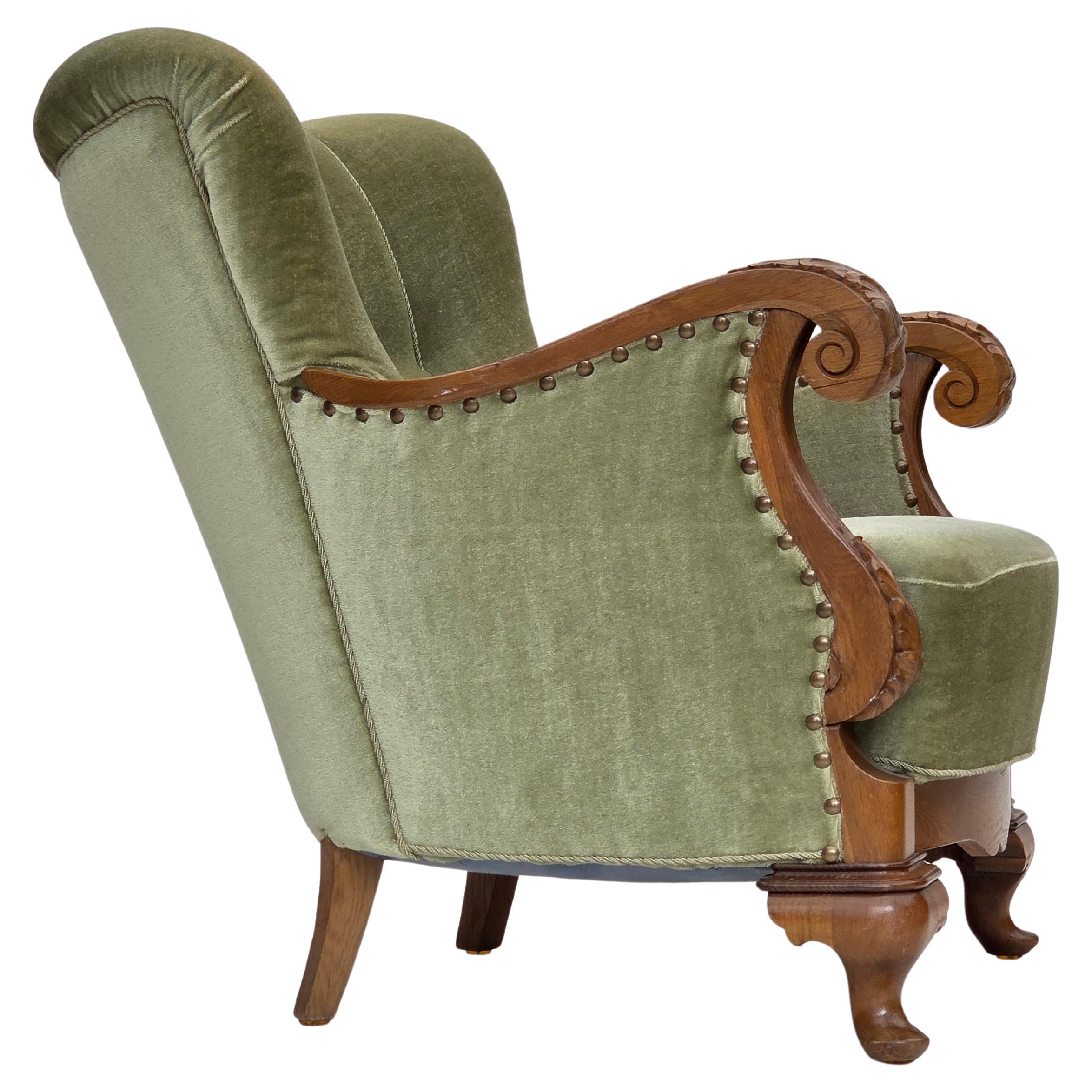 Poltrona danese degli anni '60, velluto verde da arredamento, legno di quercia intagliato.