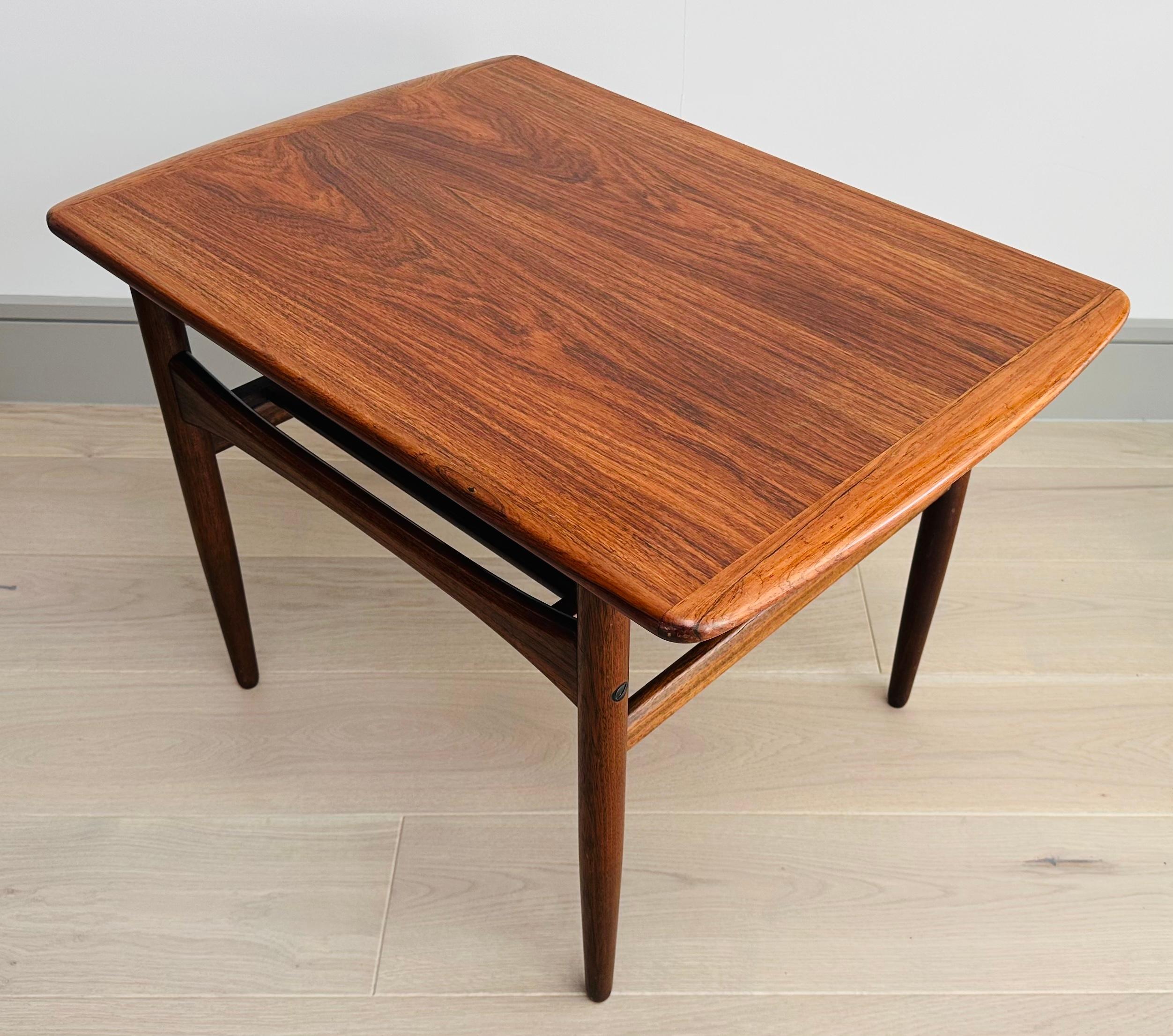 A small Danish rosewood coffee or side table which was manufactured by Arrebo Møbler and designed by Robert Christensen during the 1960s. An excellent example of Danish design with beautiful grain and patina.  The table features curved edges and a