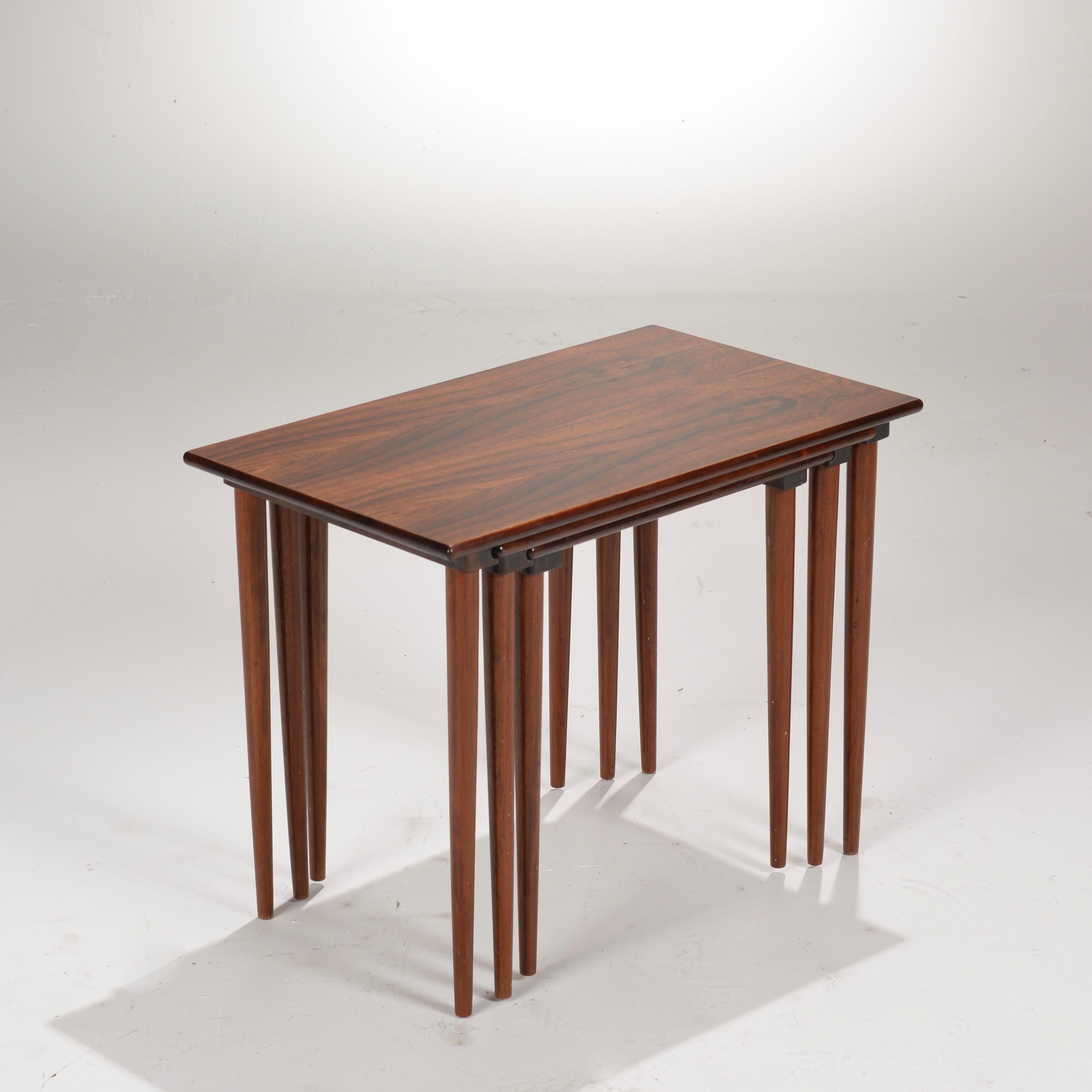 Stunning set of Danish made Brazilian rosewood nesting tables. The smaller tables actually nest into the bottom overlapping grove of its larger table, enabling the set to be picked up and moved as a set. 

All items are viewable at our Los Angeles