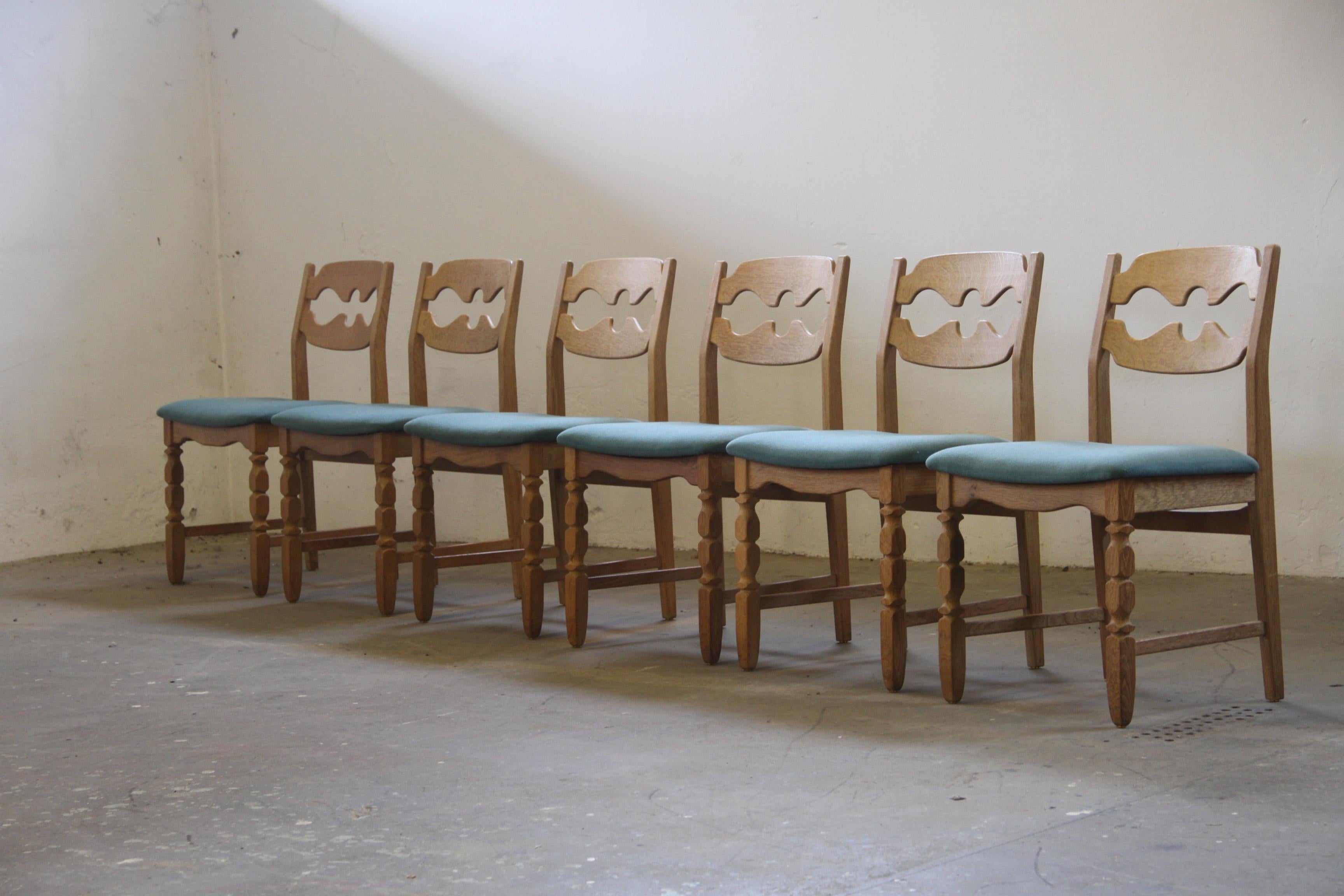 Le straordinarie sedie da pranzo di Henning Kjærnulf, realizzate in legno di quercia, mostrano un'accattivante miscela di influenze brutaliste/barocche e moderne di metà secolo. Conosciute come modello Razorblade, queste sedie classiche sono state