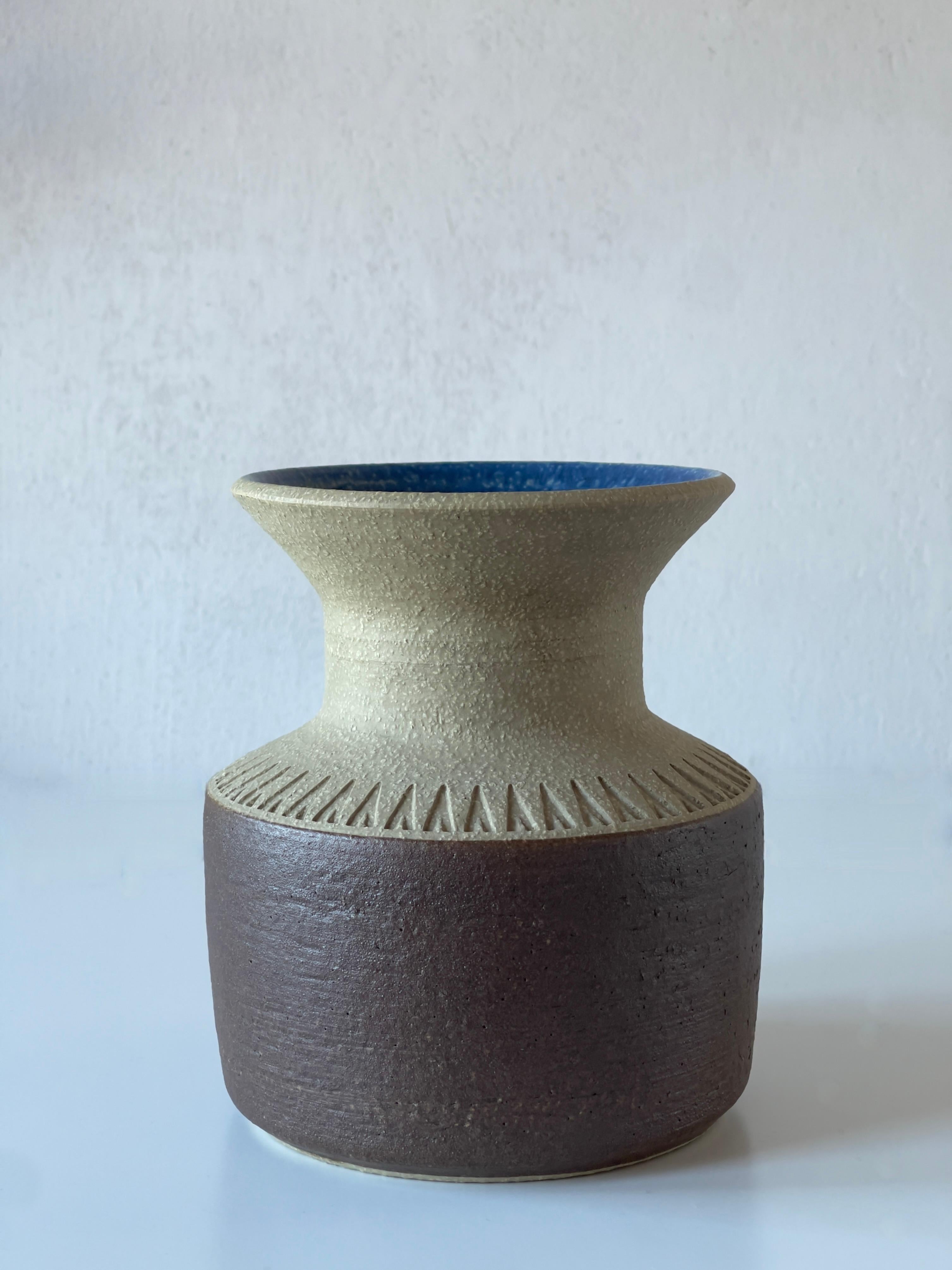 Ce vase en grès des années 1960, conçu par le céramiste danois Einar Johansen pour la poterie Søholm sur l'île de Bornholm, est un exemple raffiné de la céramique danoise du milieu du siècle. 

Le vase est fabriqué à partir d'une base en grès brun
