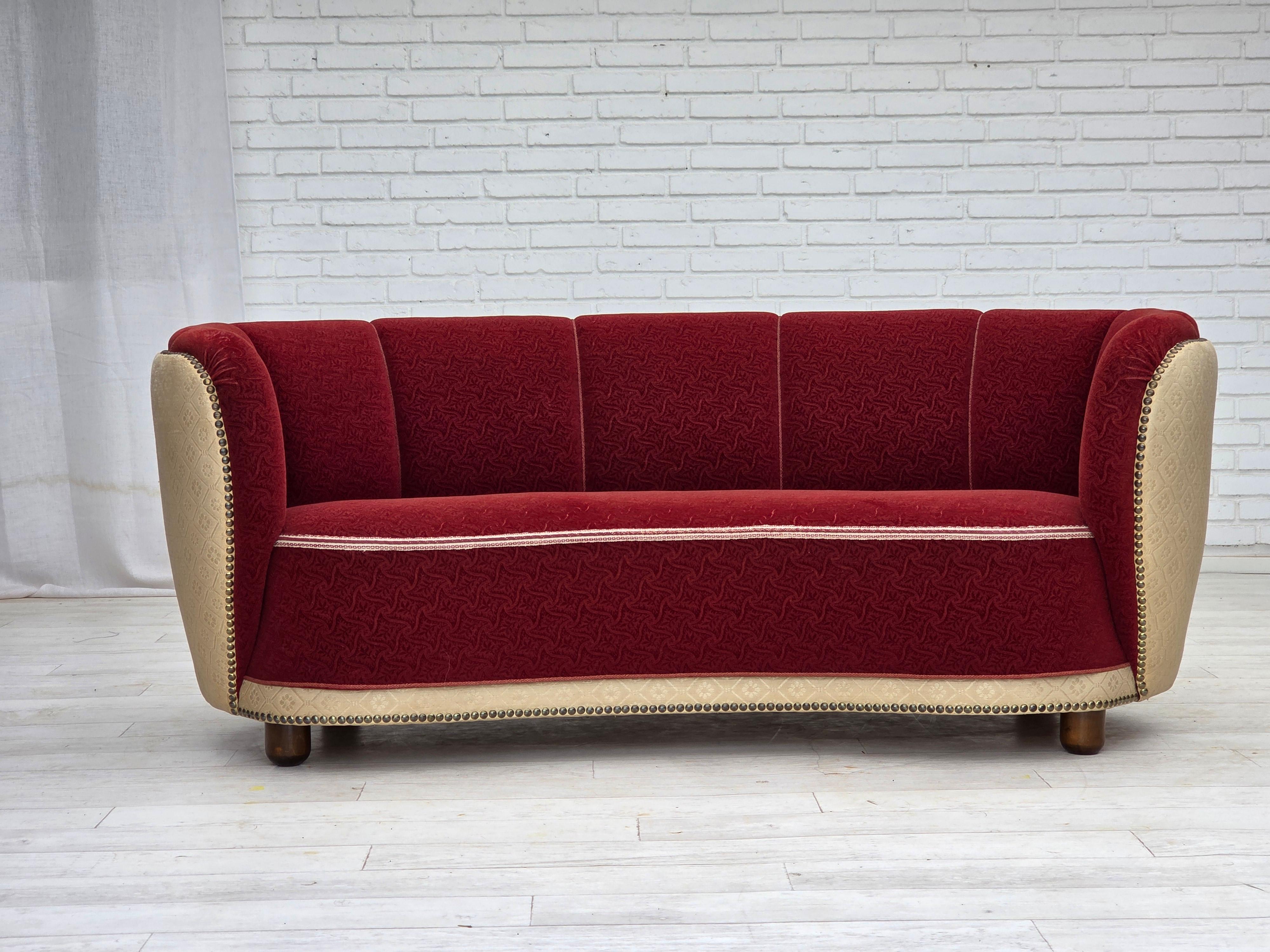 1960s, Danish curved 2-seater sofa. Original red and beige furniture wool fabric, brass springs in the seat, beech wood legs. Original good condition: no smells, no stains and stable construction. Manufactured by Danish furniture maker in about