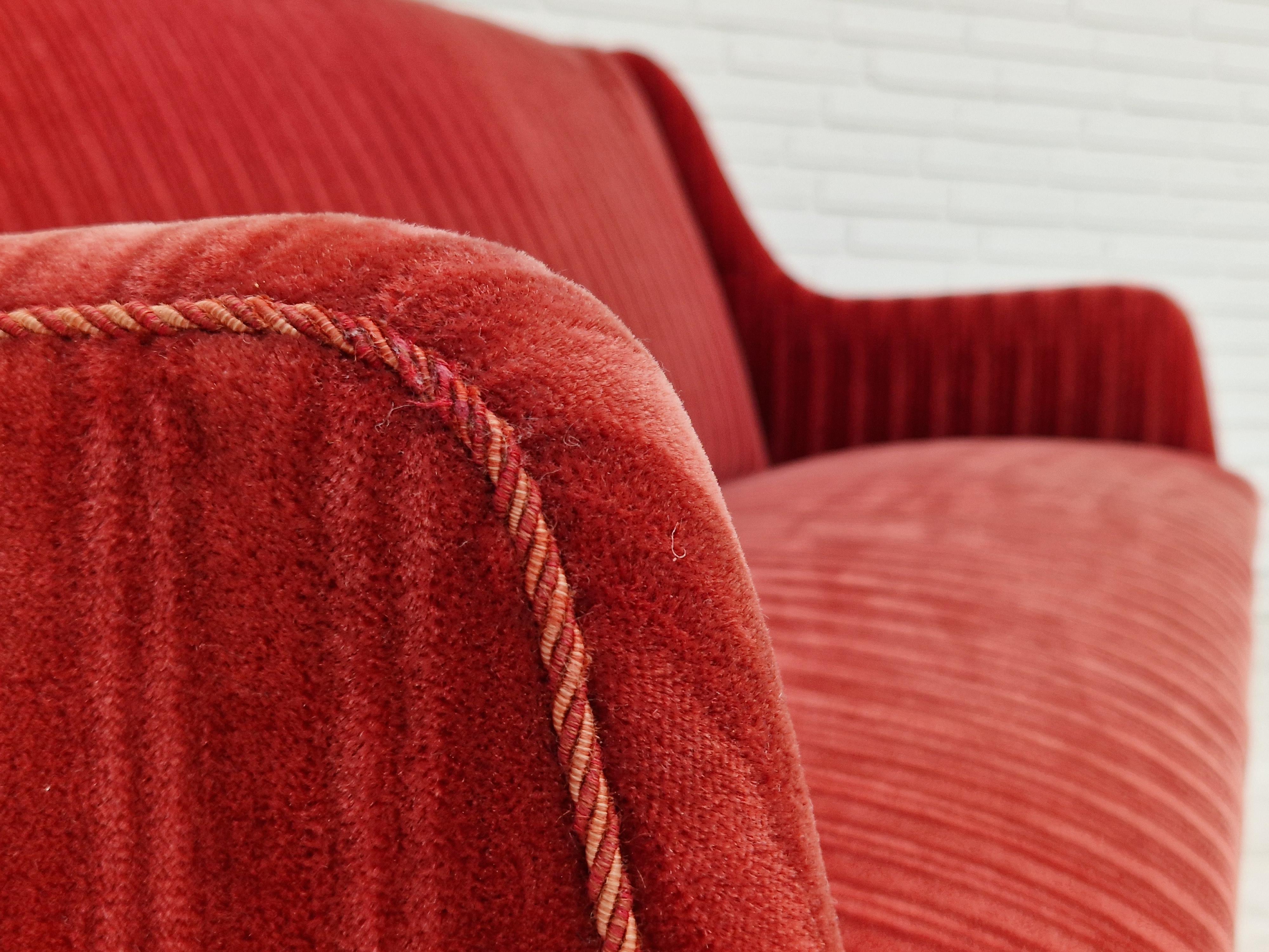 1960s, Danish design, original very good condition, no smells, no stains. 2 seater sofa, red velour fabric, no smels. Legs of beech wood. Springs in seats. Manufactured by a Danish furniture manufacturer in about 1960. Checked by professional