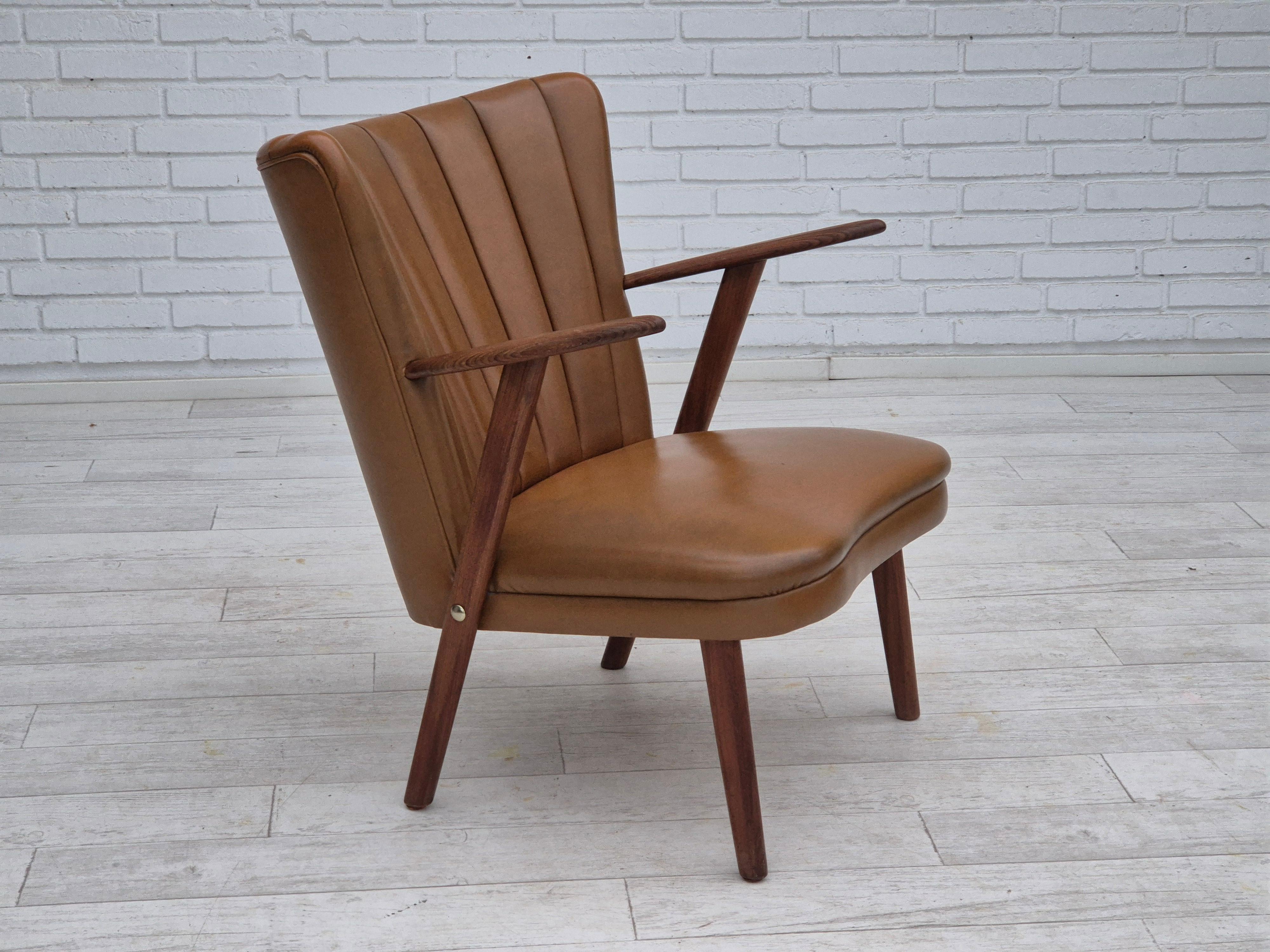 Années 1960, design danois par Erhardsen & Andersen. Fauteuil en très bon état d'origine : pas d'odeurs, pas de taches, et construction stable. Meuble original en cuir écologique marron, bois de teck massif. Fabriqué par le fabricant de meubles