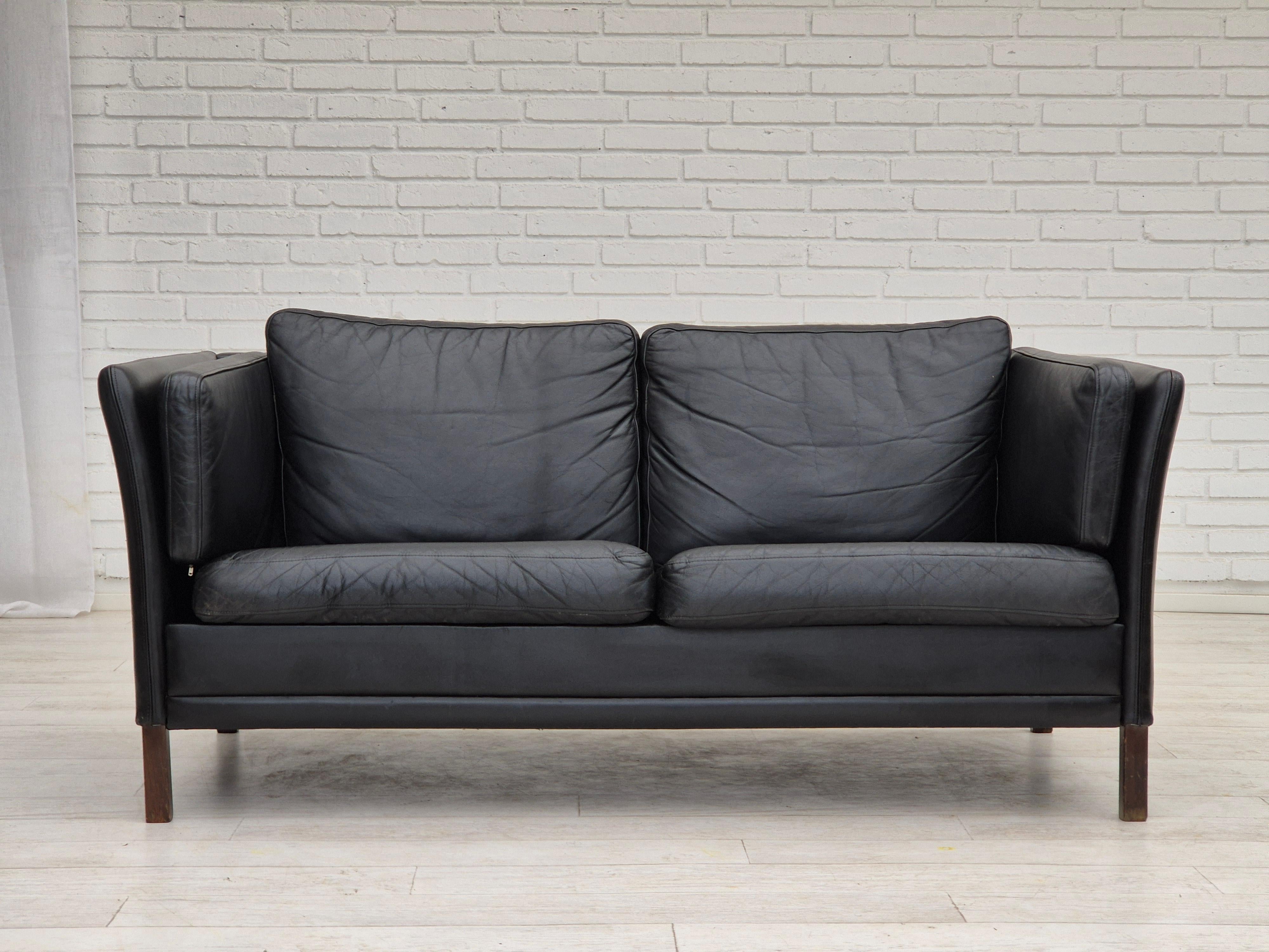 1960er Jahre, dänisches Design von Mogens Hansen. 2-Sitzer-Sofa in sehr gutem Originalzustand: keine Gerüche und keine Flecken. Schwarzes Leder, Beine aus Eschenholz. Hergestellt von einem dänischen Möbelhersteller etwa in den 1960-65er Jahren.