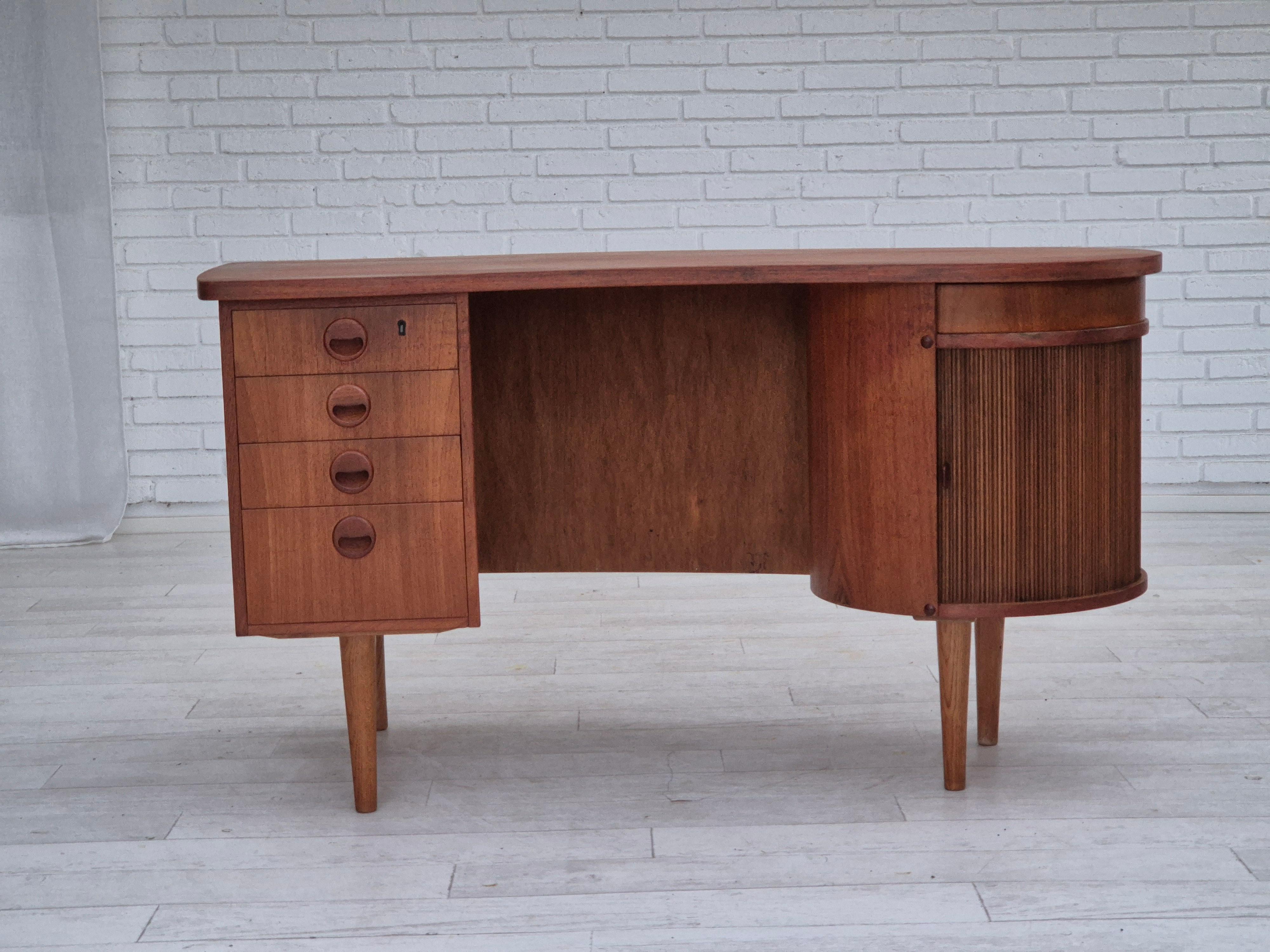 1960s, Danish design by Tibergaard Nielsen for Ikast Møbelfabrik. Free standing desk with rotating bar section. Brass accents on the front in the bar. Roll front door, drawers, round rotating drawer, mirror in the bar. Teak wood, legs of oak wood.