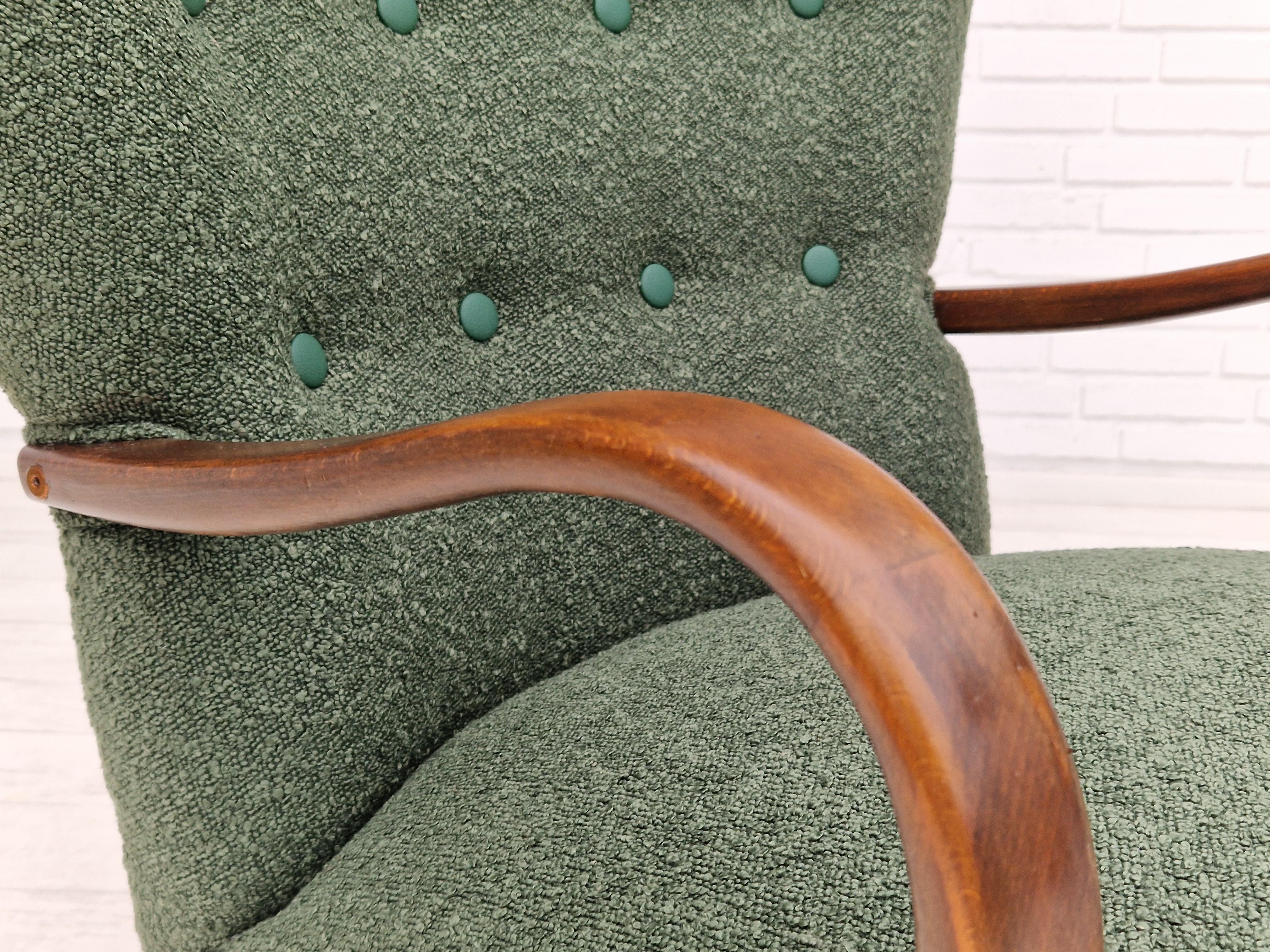 60s, Danish designed armchair. Completely renovated-reupholstered in quality bottle green furniture fabric. Brand new upholstery, original brass springs in the seat are retained. Artificial leather buttons. Legs and armrests in stained beech wood.
