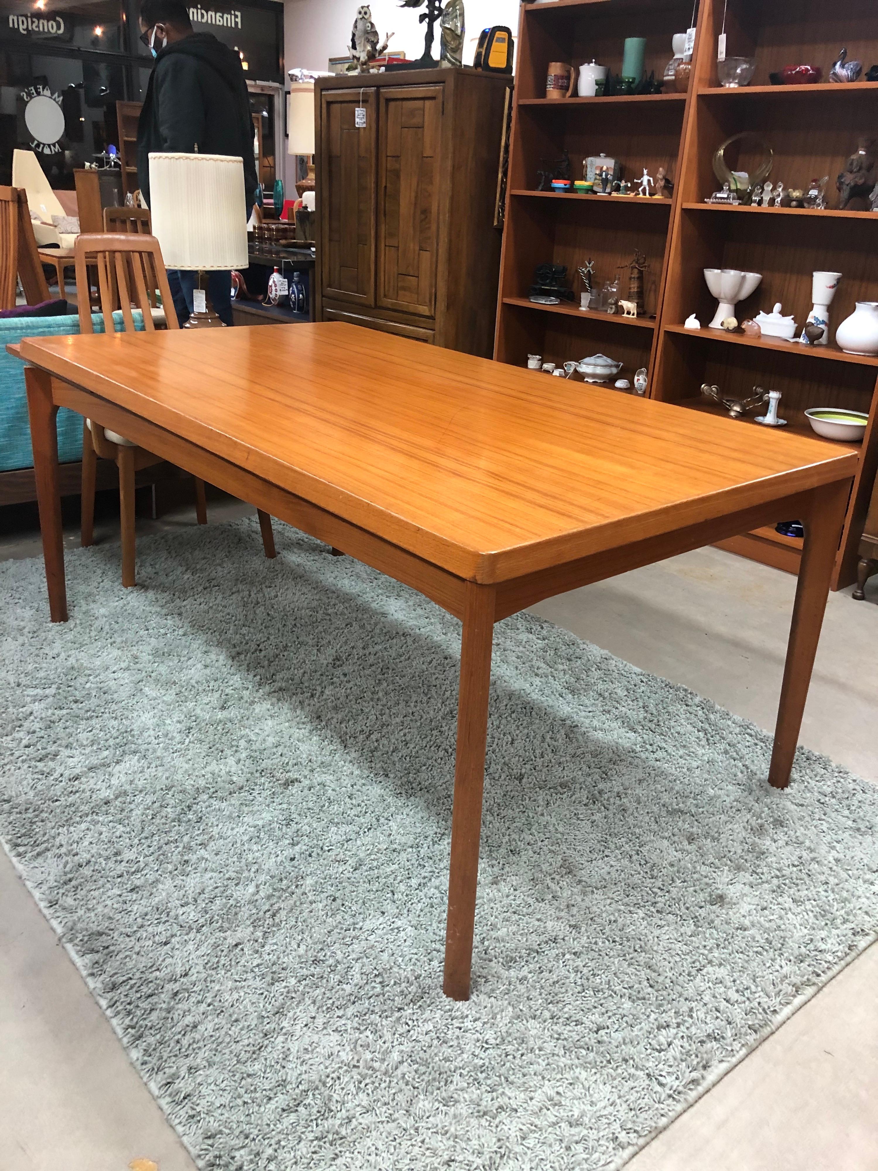 This large draw leaf Vejle stole dining table stands firm in its solid pine core covered with a teak veneer. Designed by Henning Kjaernulf for Vejle Stole og Møbelfabrik, this hefty beauty boasts solid teak legs and gorgeous edge banding. The