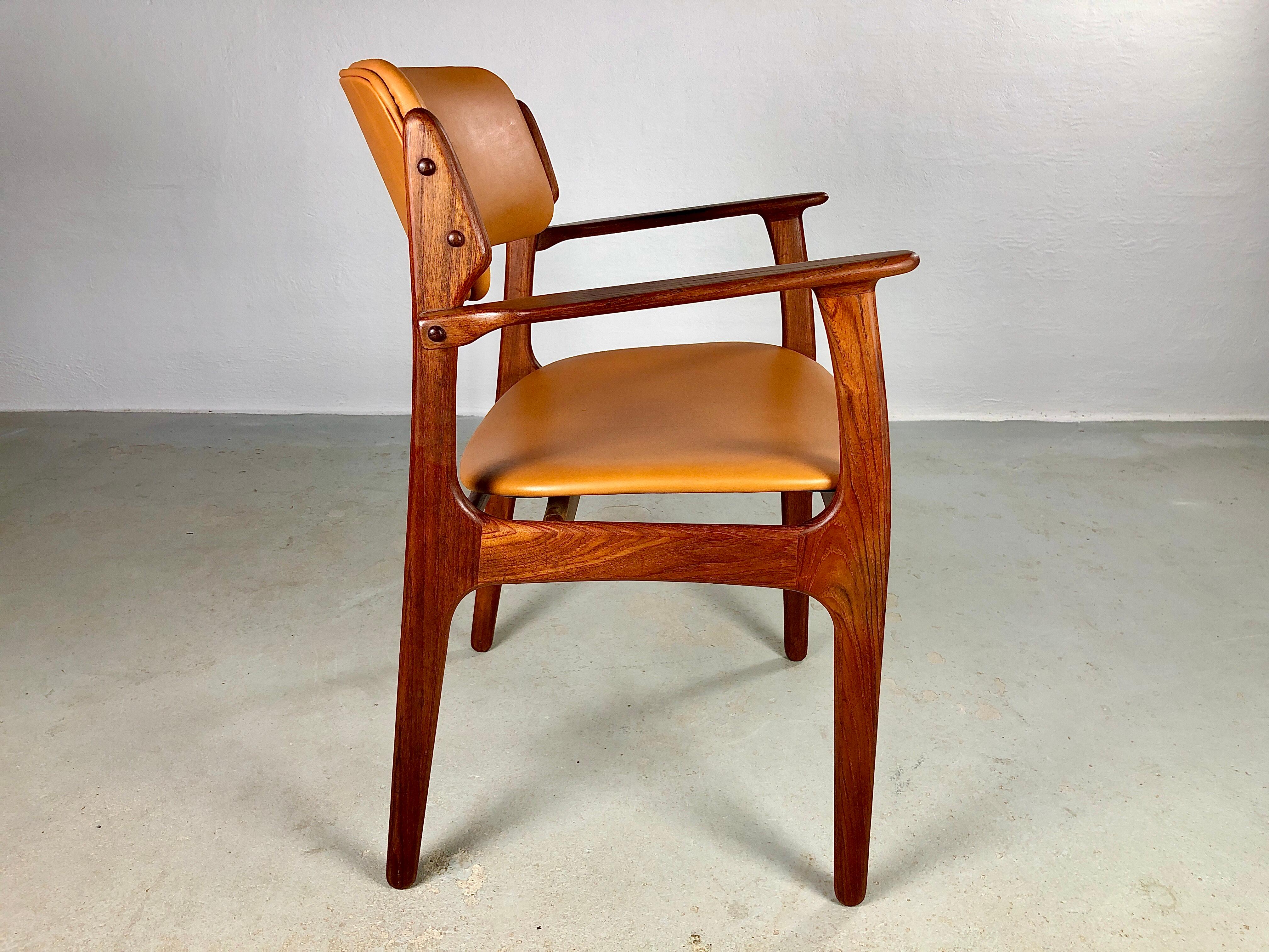 Erik Buch fully restored teak armchairs with excellent woodwork that are evidence of good mid-century Danish design and craftsmanship.

The chairs feature a solid teak with Erik Buch's characteristic floating seat and rounded backrest that ensures a