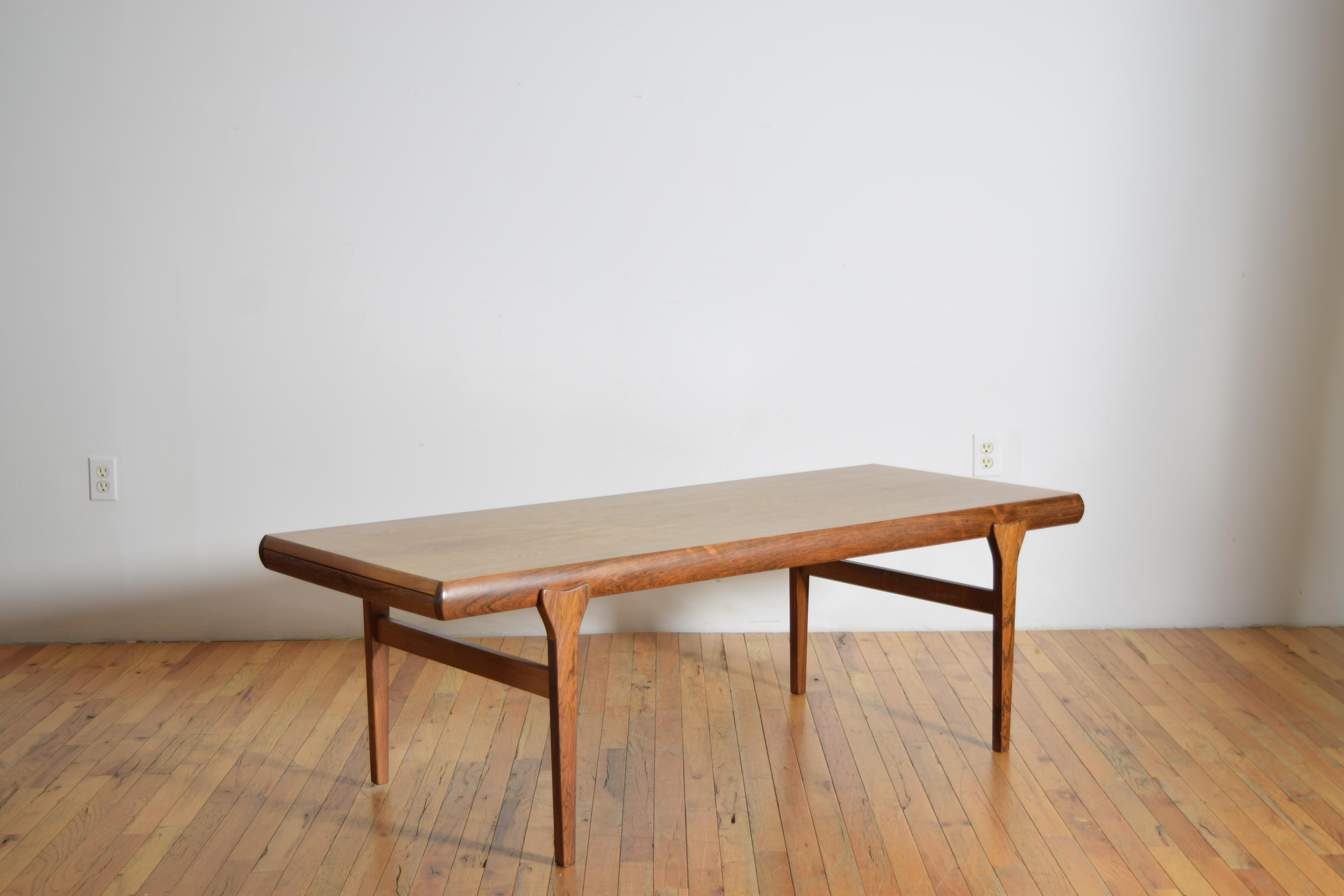 Cette table basse en teck, conçue par Johannes Andersen et produite par CFC Silkeborg, présente un magnifique grain de bois de teck, des pieds sculpturaux en teck massif et une rallonge de table et un tiroir extensibles cachés.
